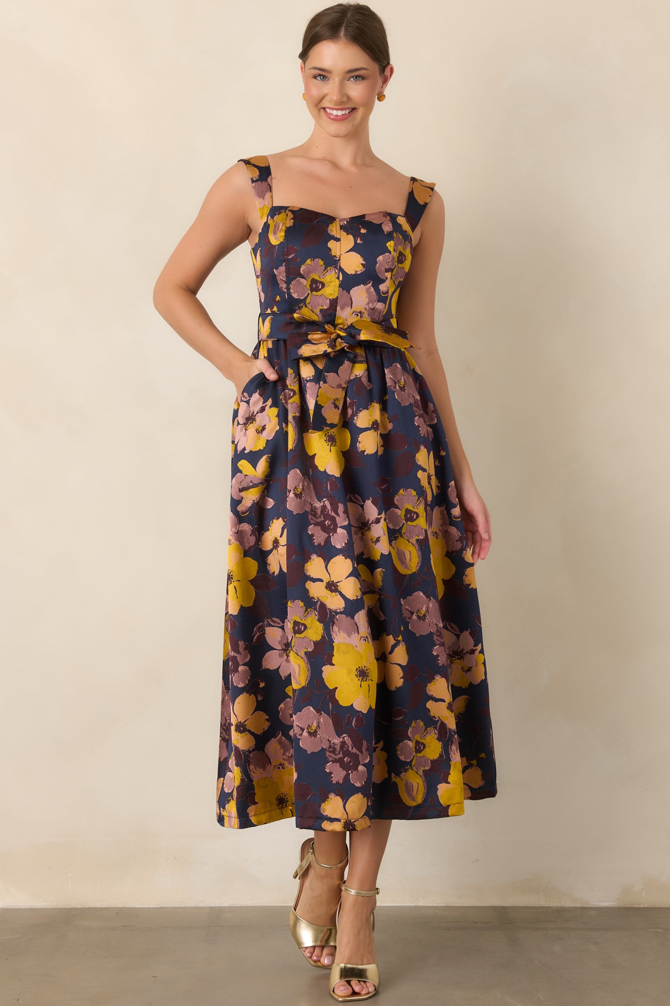 Deep navy dress with a fitted floral bodice, adjustable-looking tie waist, and voluminous gathered midi skirt.