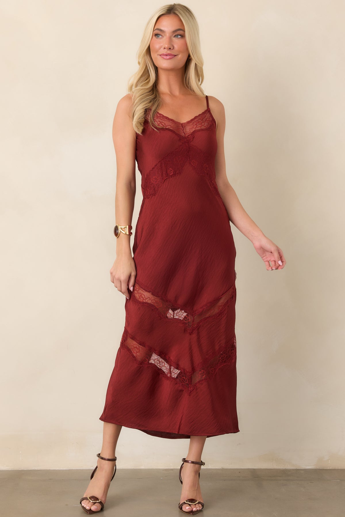 Deep red satin midi dress with a softly fitted shape, lace V-neckline, and angled floral lace accents
