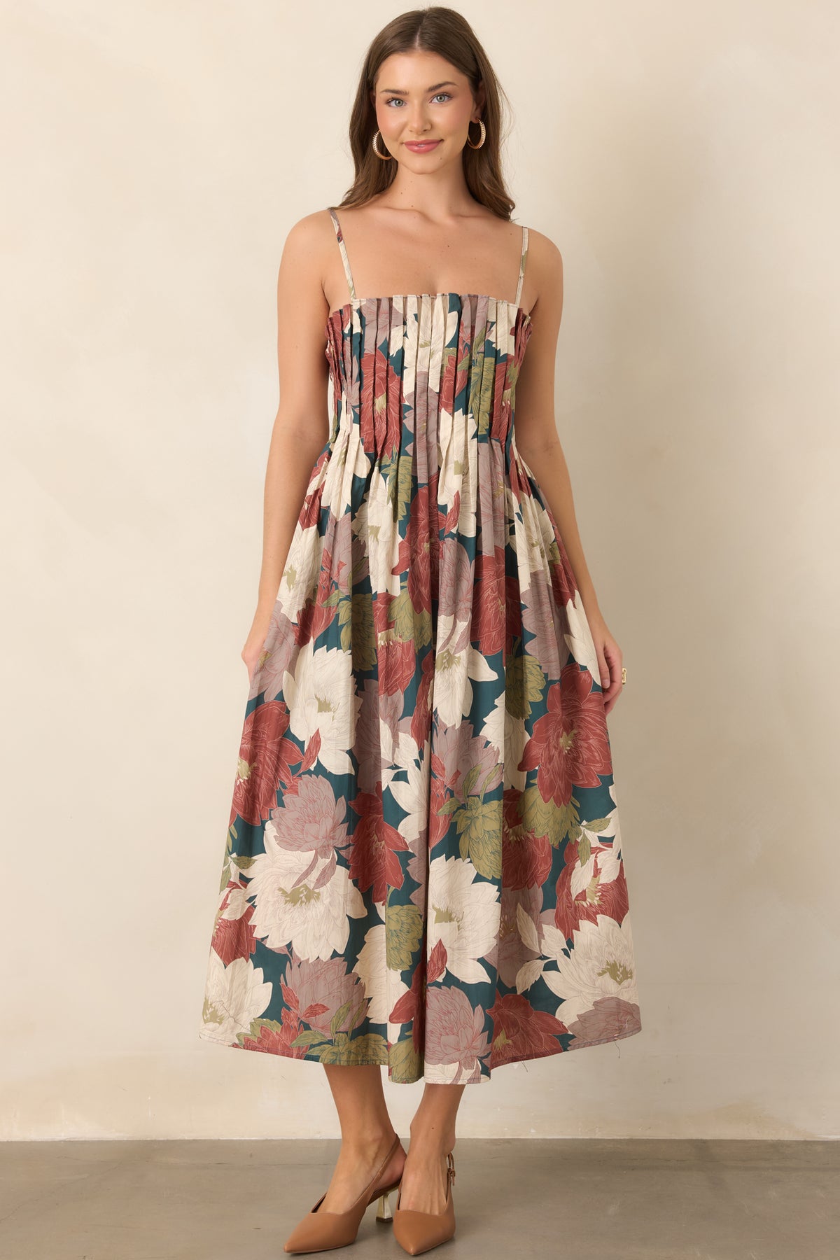 Deep teal dress showcasing rich oversized florals, slender adjustable straps, and a full skirt.