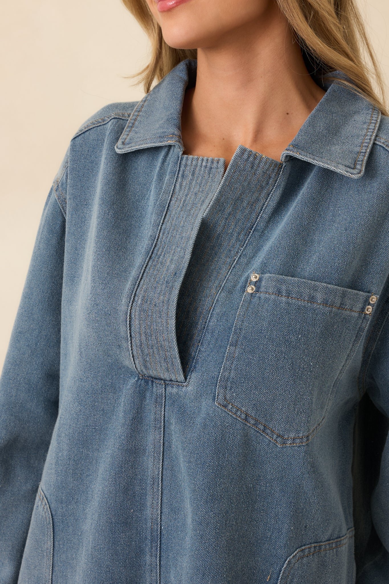 Detailed close-up of the indigo denim mini dress focusing on the partial button placket and collar.