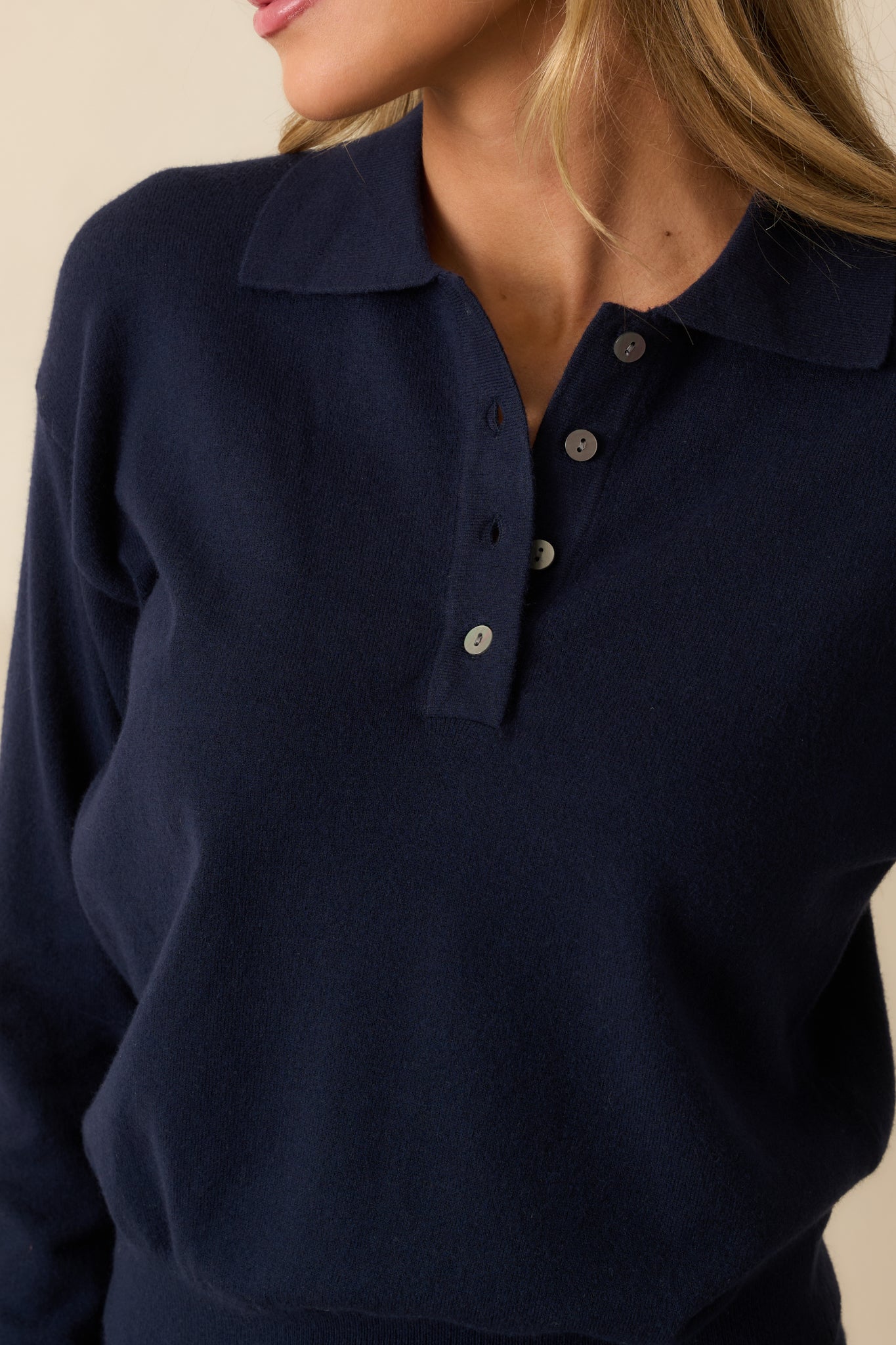 Detailed shot of the knit fabric showing the ribbed texture, collar, and button placket.