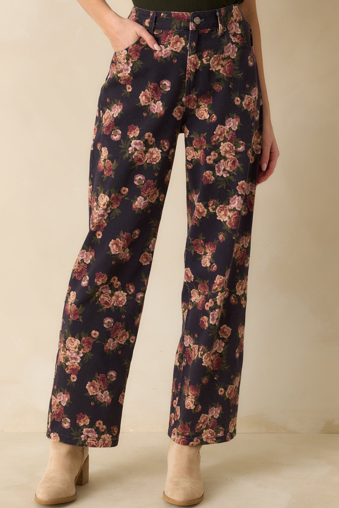 Detail of navy jeans’ midsection showing floral pattern and straight-leg design.
