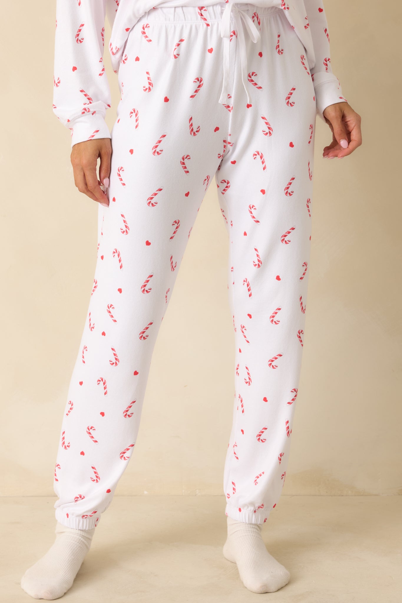 Detail of front of white knit pajama pants, emphasizing elastic waist, cuffed hems, and smooth jersey finish.