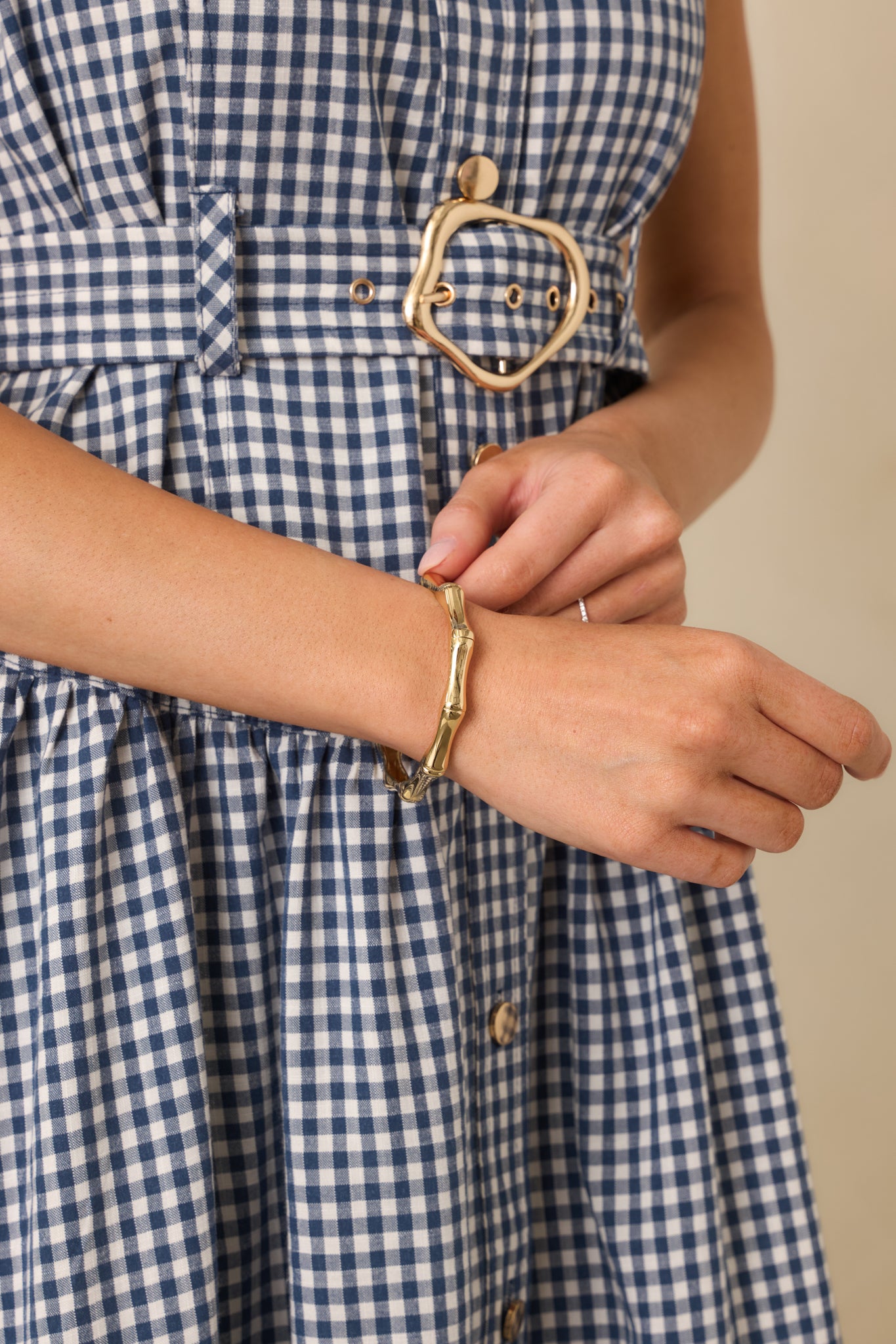 Close-up detail of the textured bamboo-style pattern and snap closure on the gold-tone bracelet.