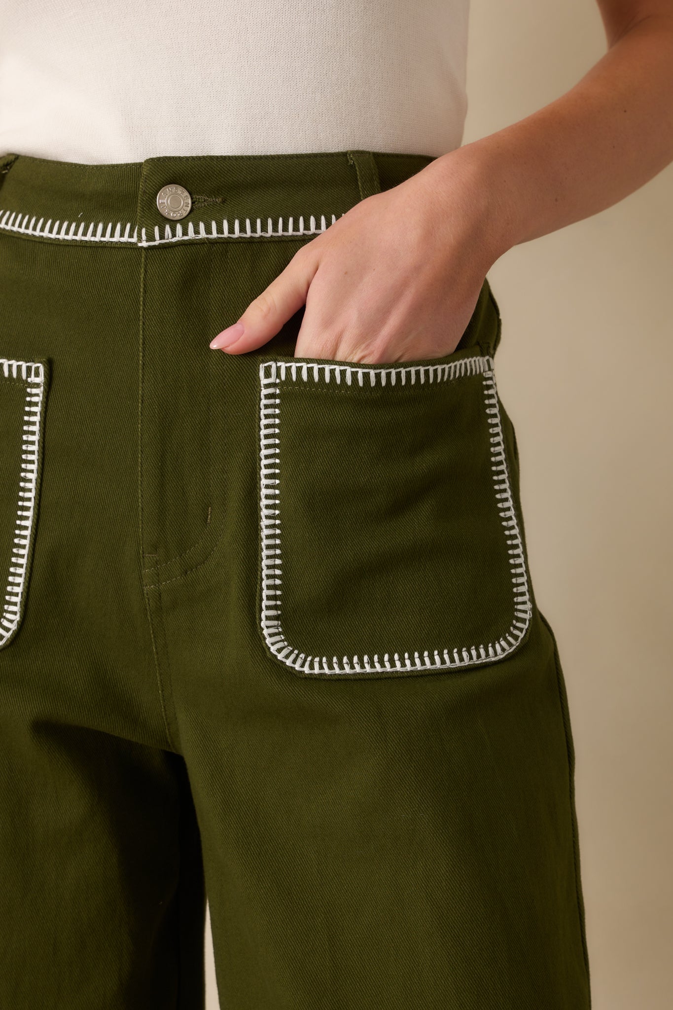 Detailed close-up of the white whipstitch trim, pockets, and waistband stitching.