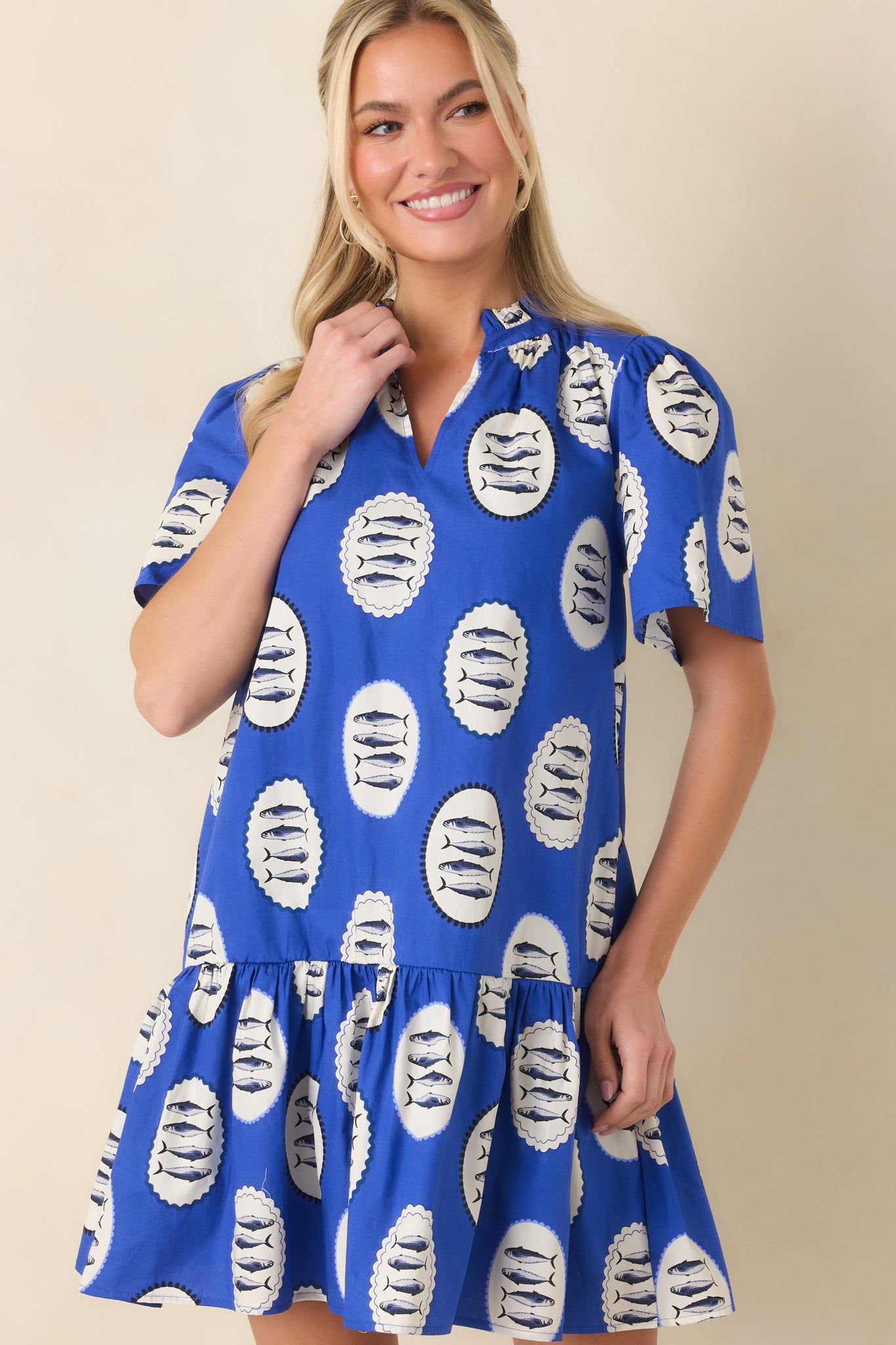 Detail of the wide short sleeves and flirty tiered hem on the cotton mini dress.