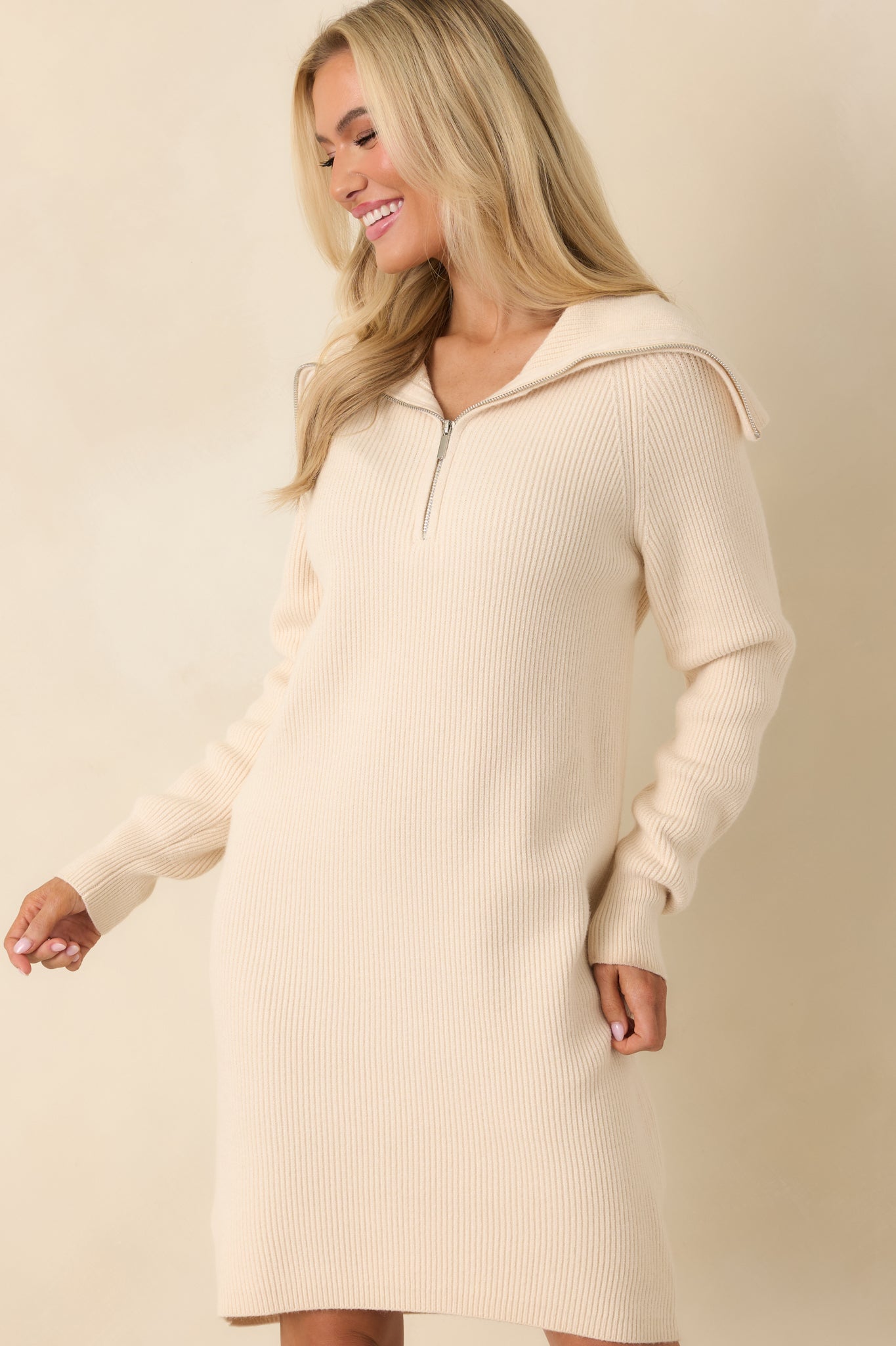 Detail of vertical ribbing and soft beige knit on sweater dress.