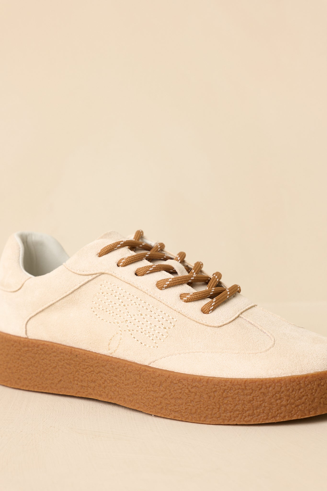 Close-up detail of the natural sneakers showing the textured rubber platform sole, stitched upper, and contrast laces.