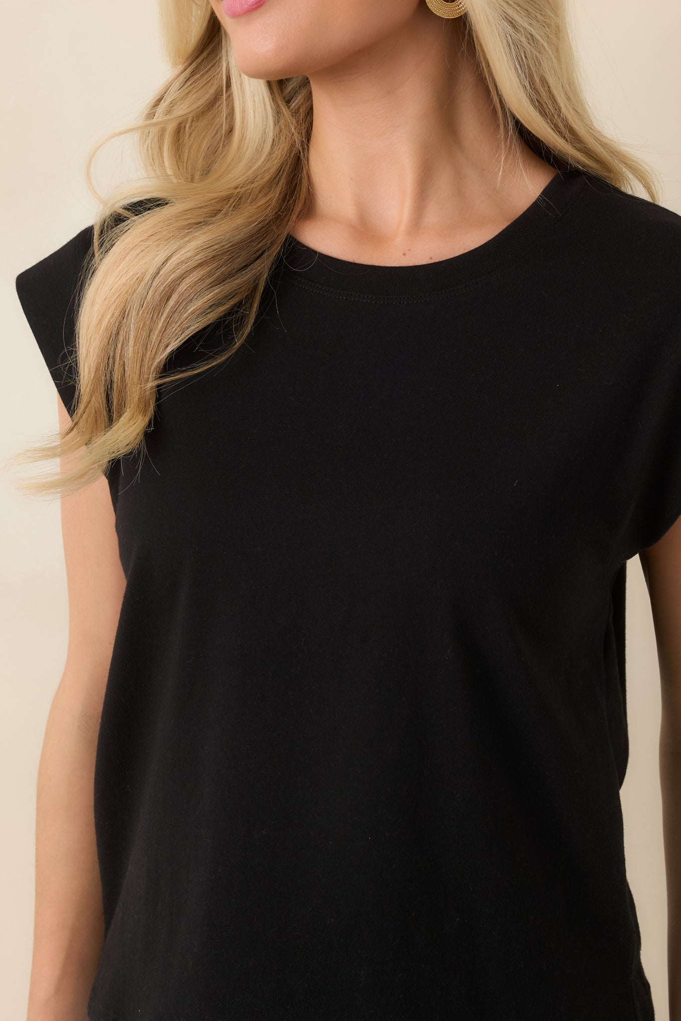 Detailed close-up of black tee highlighting soft cotton jersey texture and subtle shoulder structure.