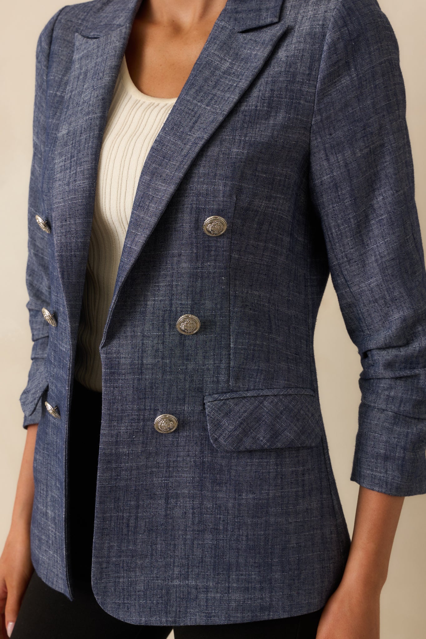 A detailed close-up of the ruched sleeve, button trim, and fabric texture.
