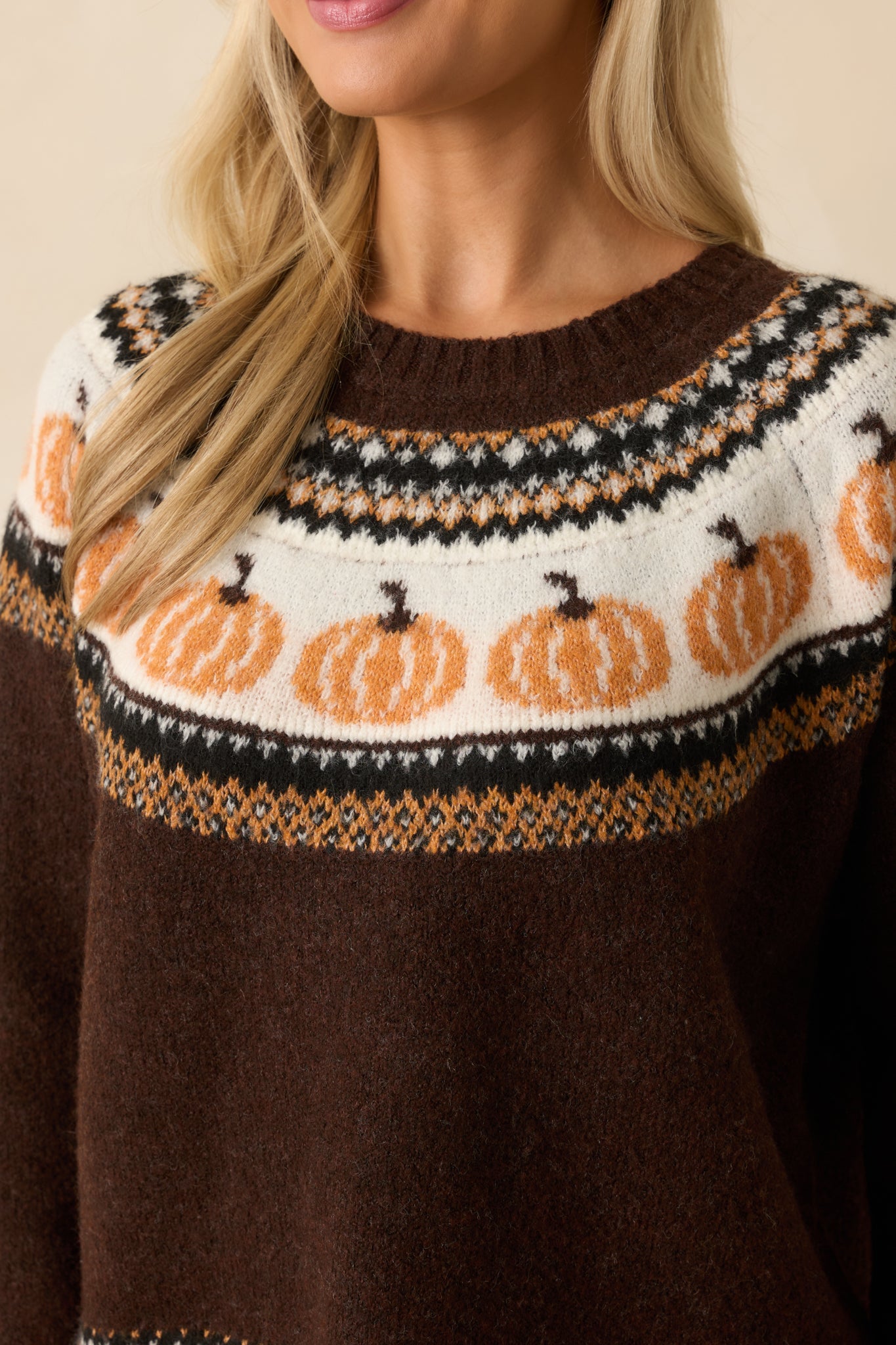 Detailed view of the soft knit texture and fair isle pumpkin pattern woven through dark brown yarn.