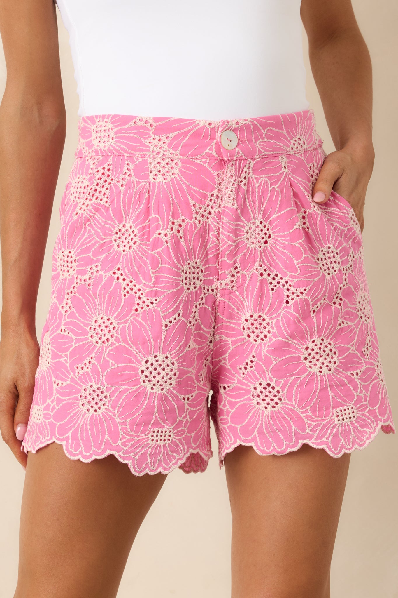 Detailed view of the floral embroidery, eyelet texture, and scalloped hemline.