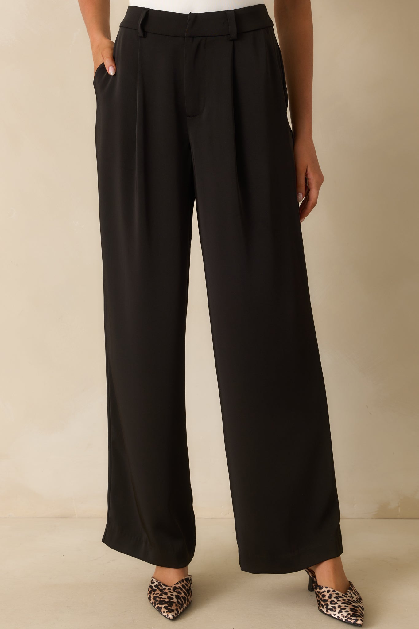 Detailed front crop of trousers showing functional side pockets and smooth fabric drape.