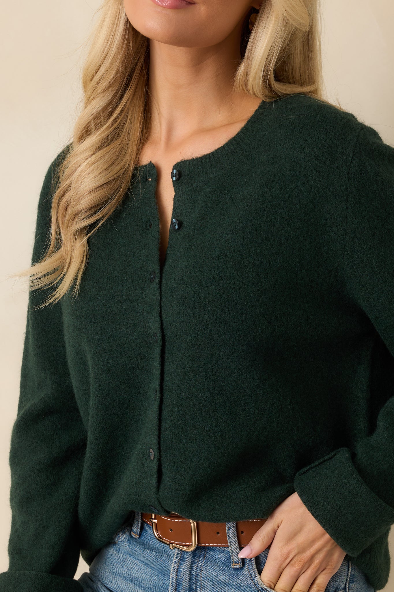 Detailed view of green knit fabric, ribbed trim, and button-front design.