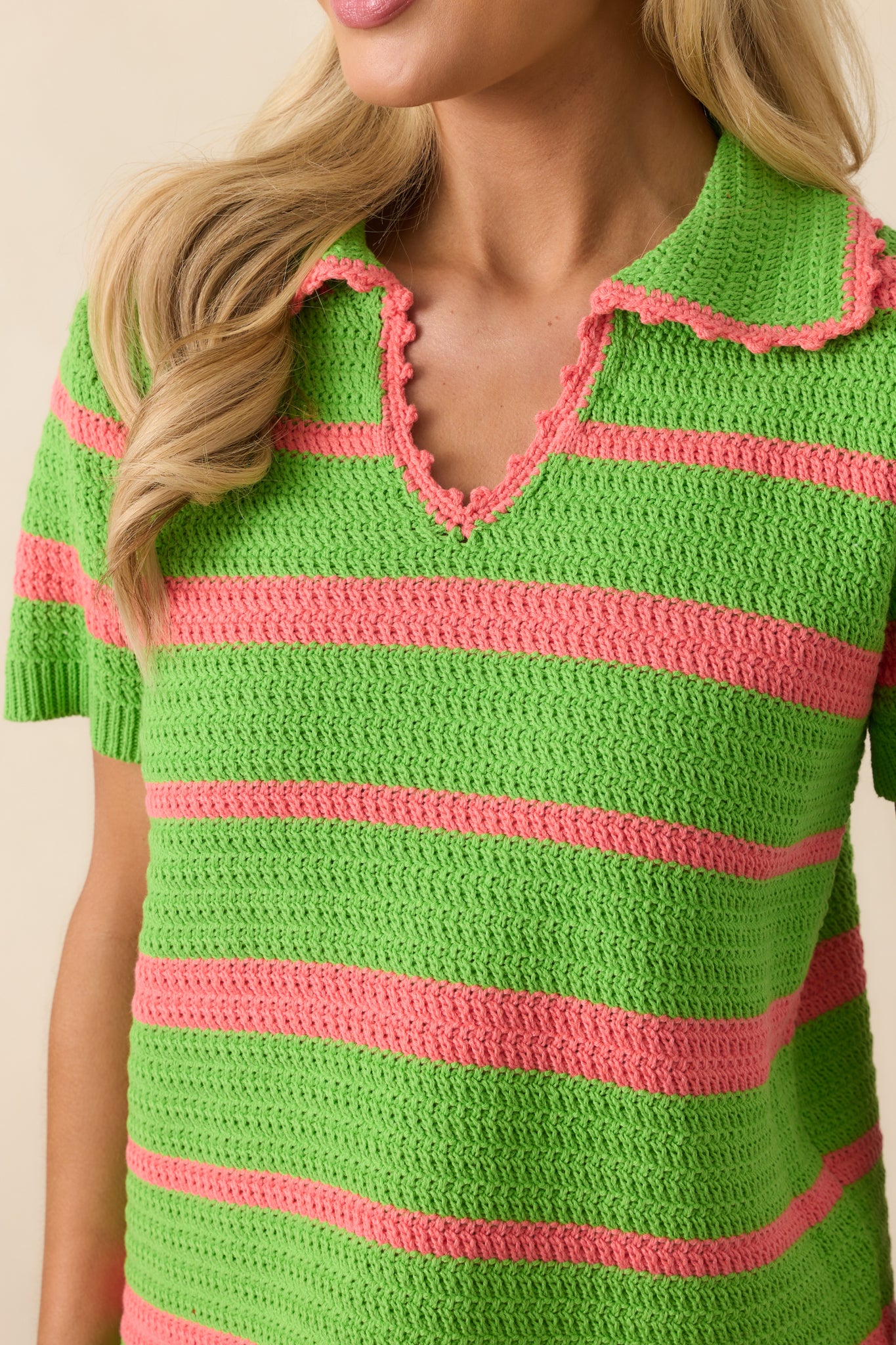 Detailed close-up of the knit fabric texture and bright green and pink stripe pattern.