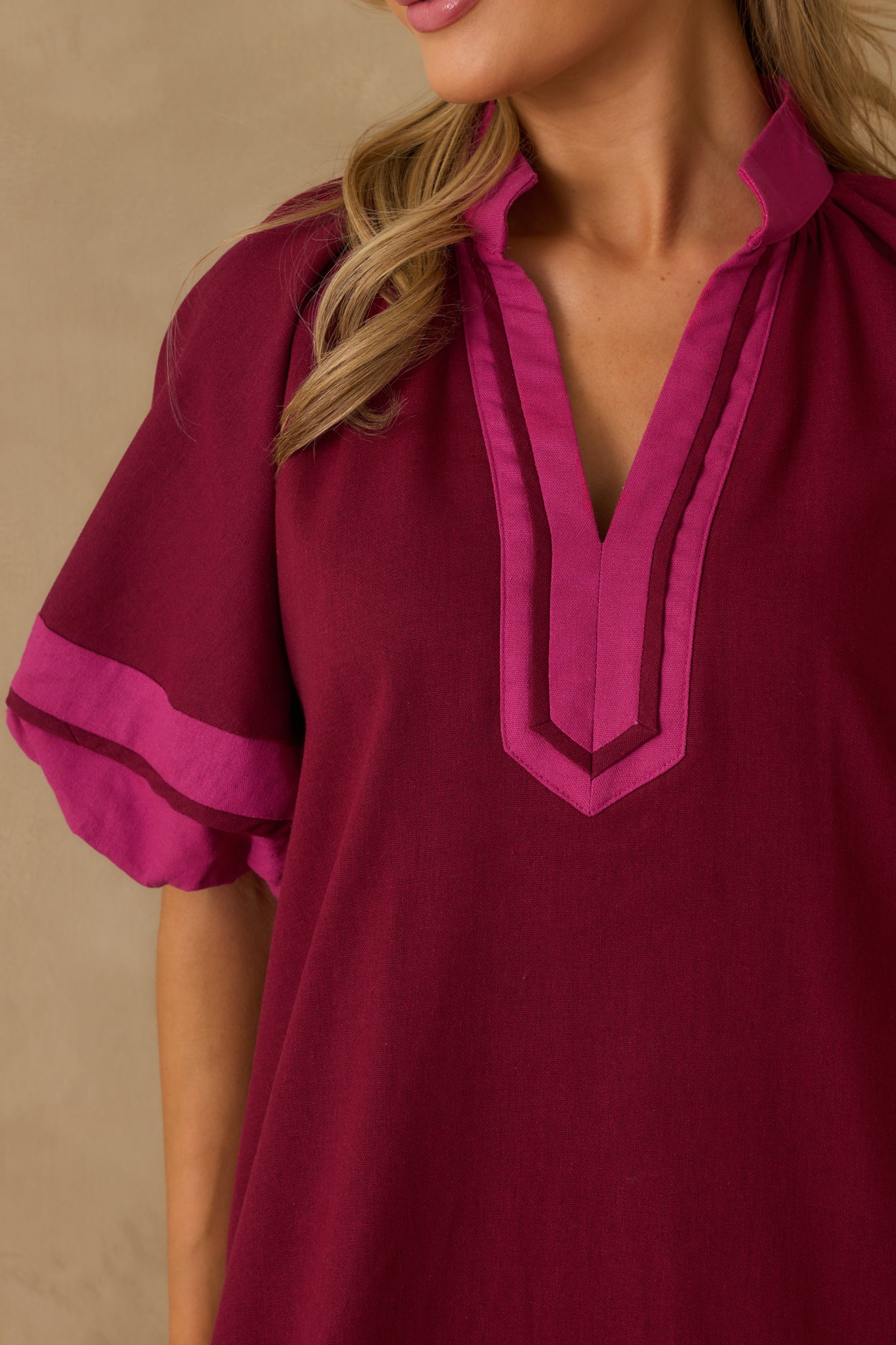 A detailed shot of the mini dress emphasizing pink contrast trim, an elastic cuff, and the fabric texture.