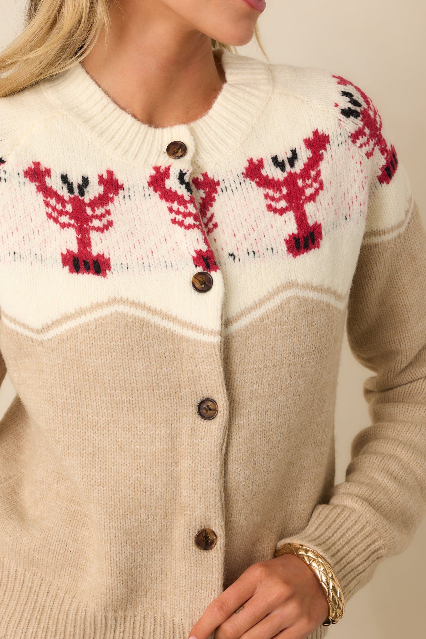 Detailed shot of the lobster intarsia knit pattern, showing the crisp contrast against the beige background.