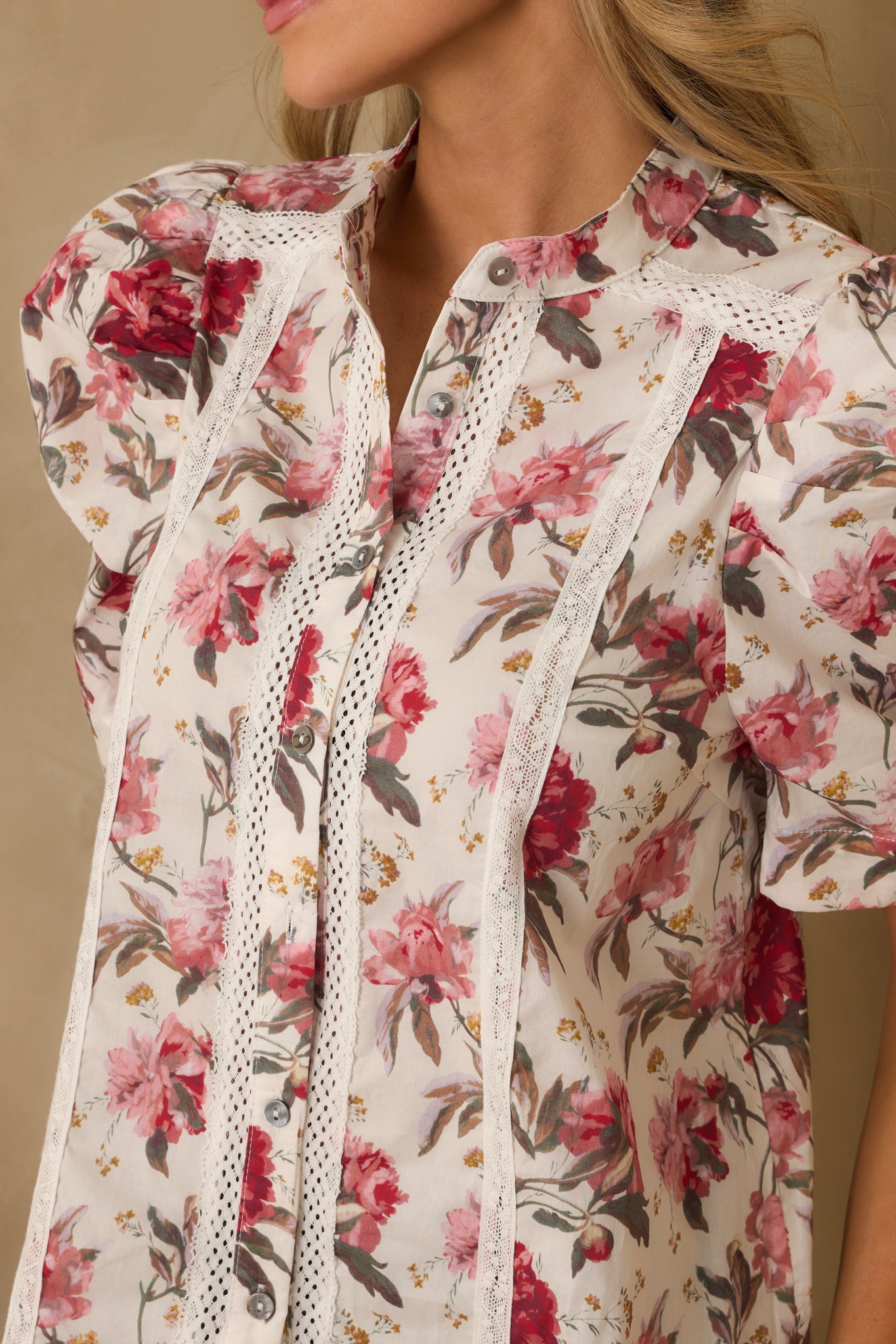 A detailed shot of the pink floral top showcasing the lace panel and button closure.