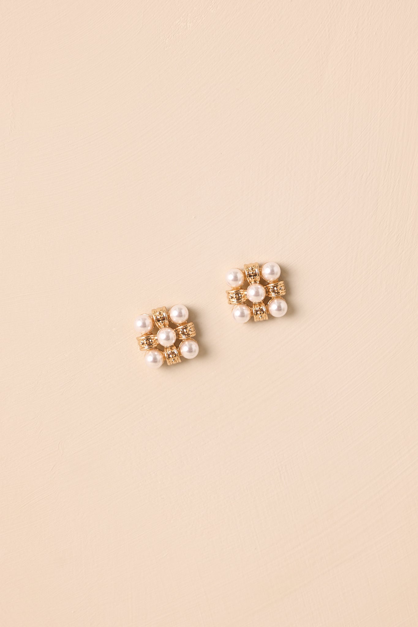 A detailed shot of the faux pearl cluster earrings highlighting the textured gold filigree spacers and symmetrical design.