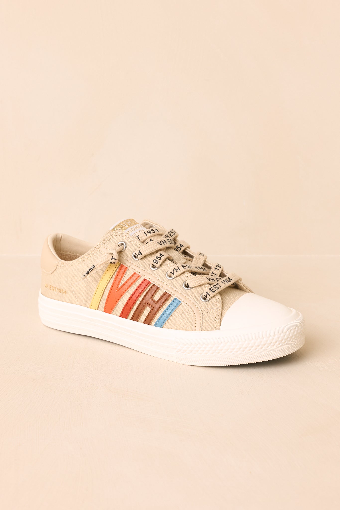 Detailed view of nude canvas sneakers featuring colorful "VH" faux leather side accents and branded lace-up closures.