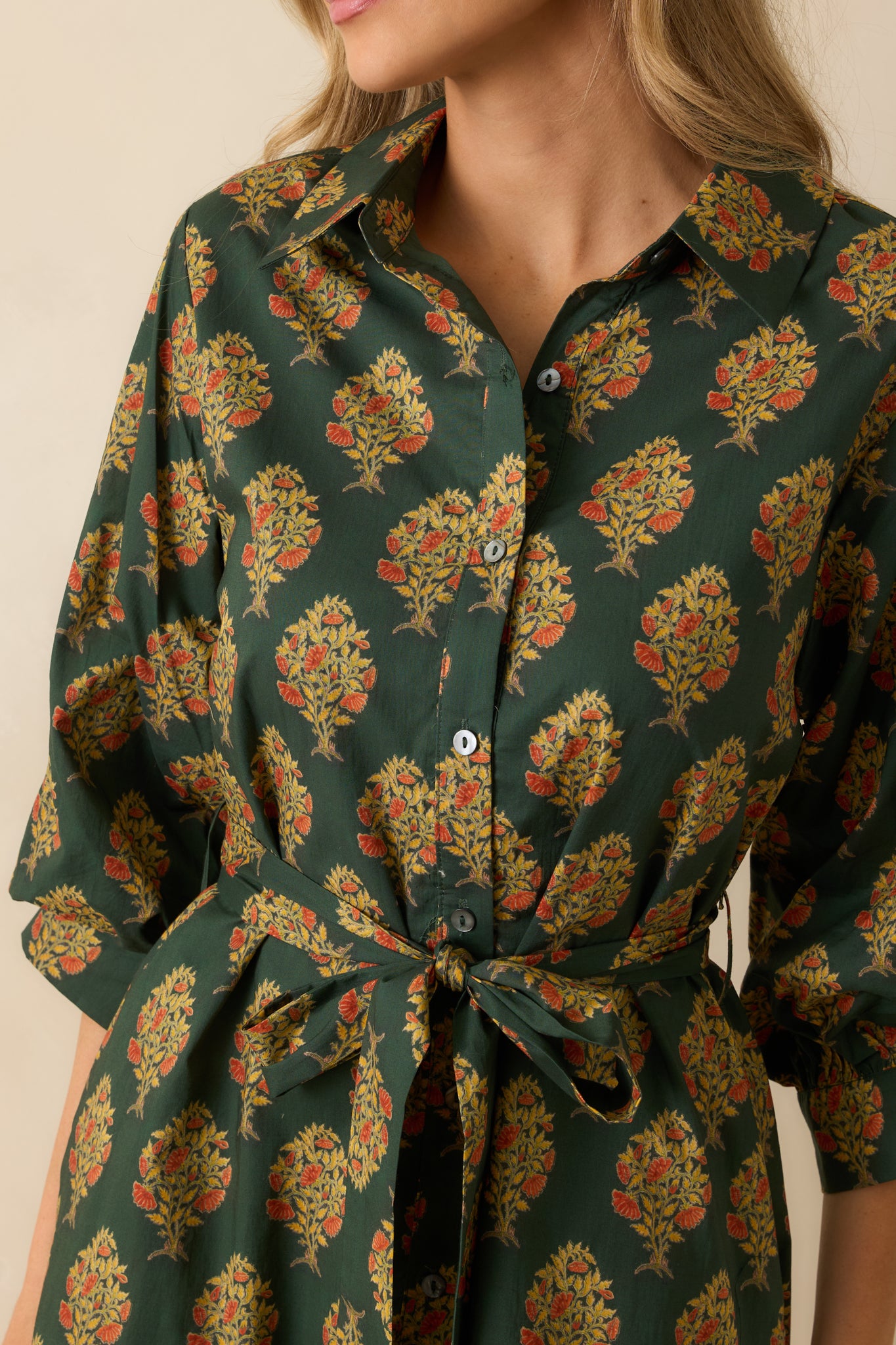Detailed view of the block floral print, button-down front, and fabric texture of the dark green maxi dress.