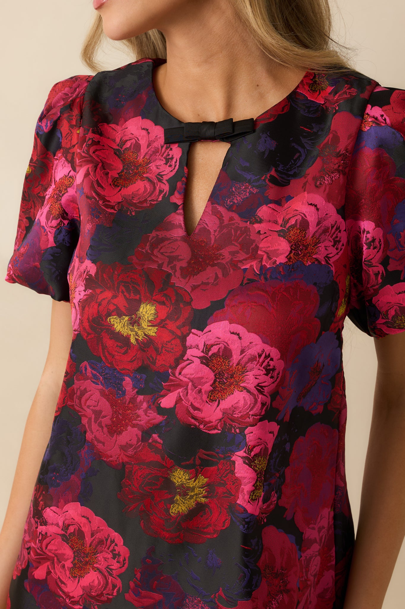 Detailed look at the multi floral jacquard fabric and bow accent on the neckline.