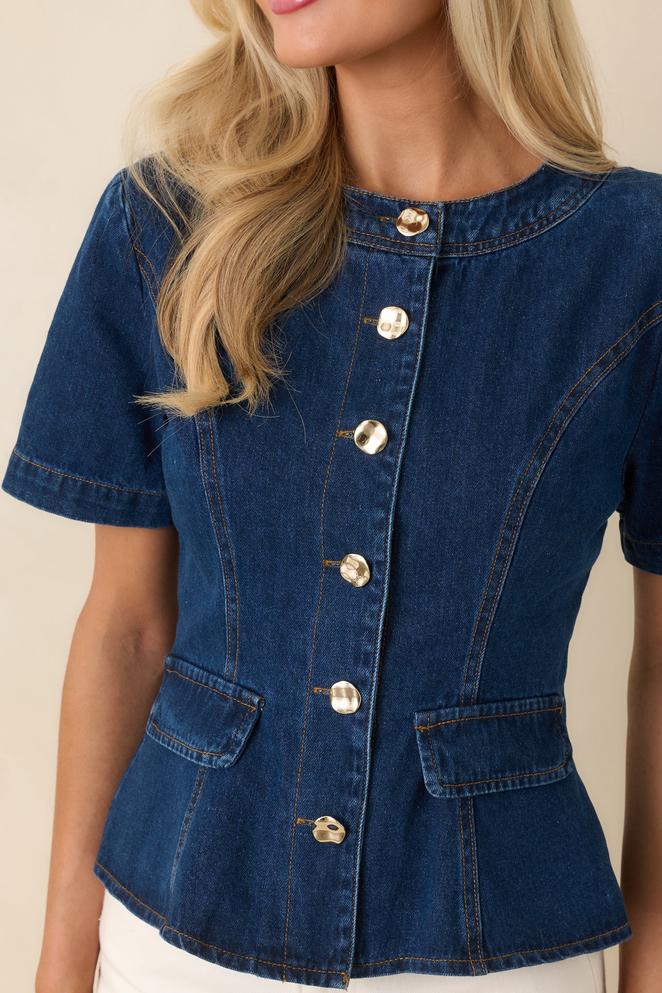 Detailed view of textured buttons against rich indigo denim fabric.