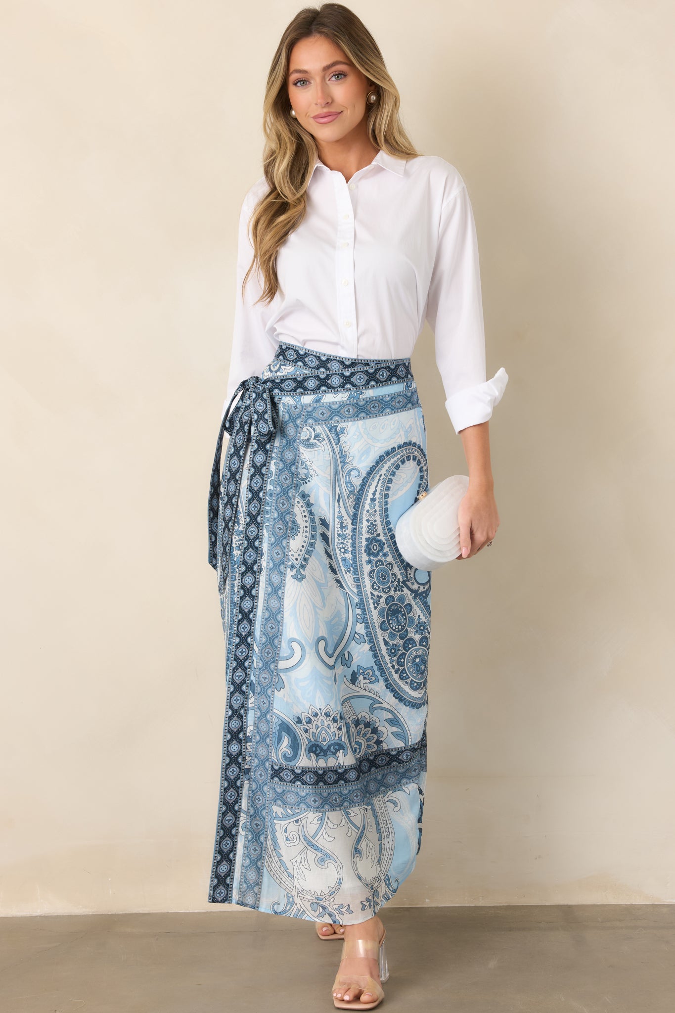 Wrap maxi skirt displaying its fluid drape, self-tie waist, and contrasting patterned trim along the hem.