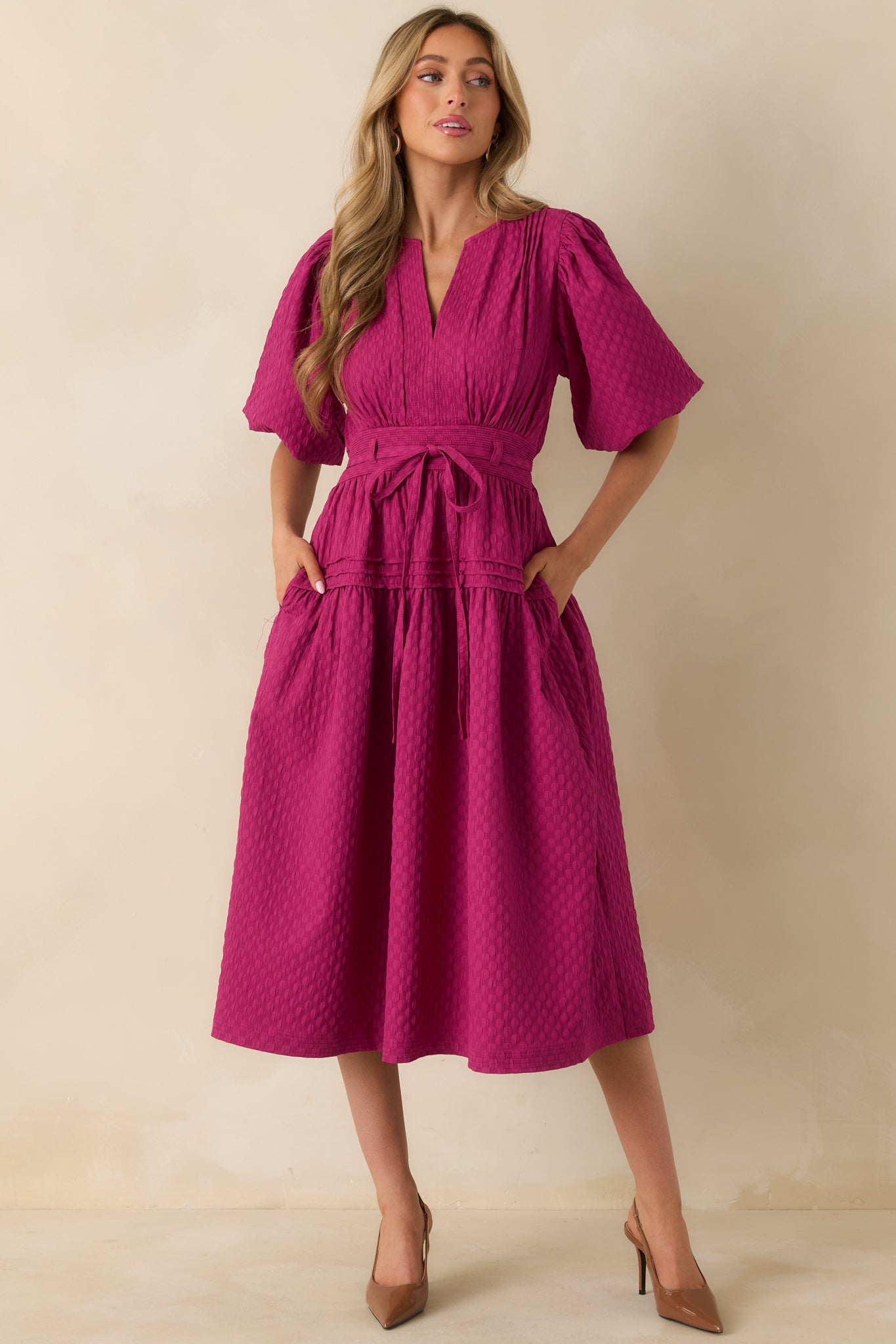 The dress displays its flowing silhouette with structured pleats on the bodice and soft puff sleeves.
