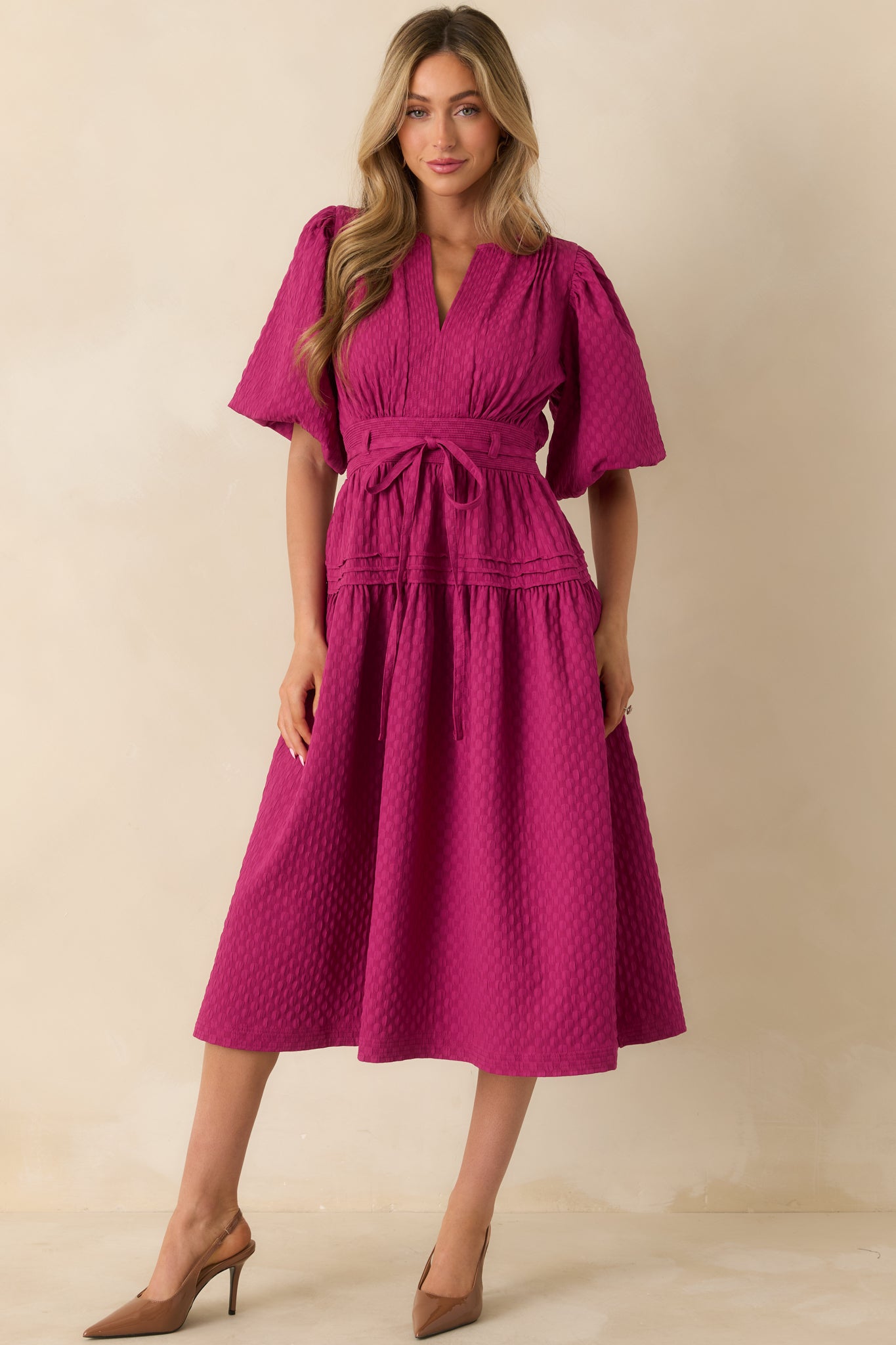 The dress features short puff sleeves, side pockets, and a full skirt with comfortable lining for a relaxed fit.