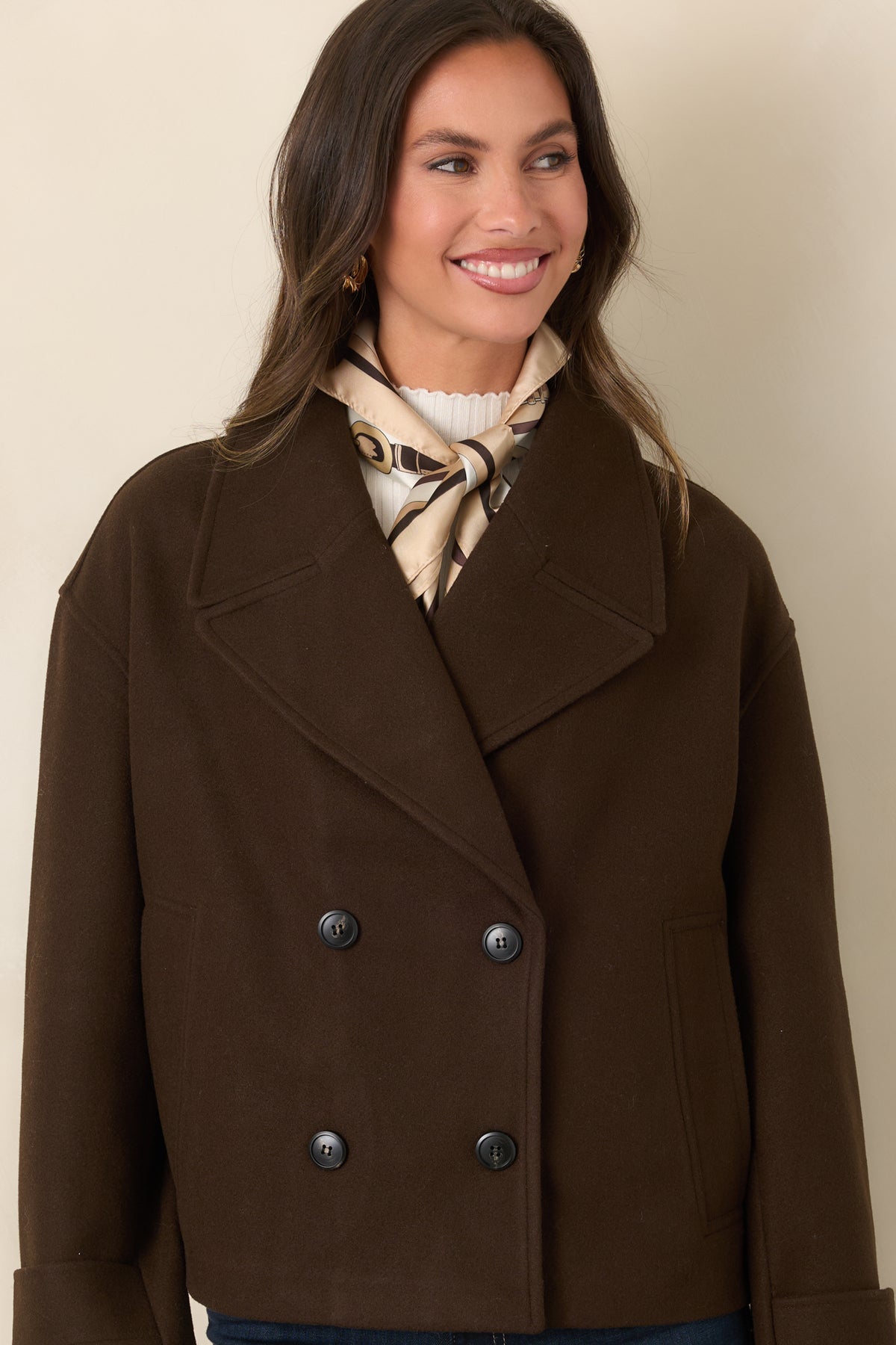 Brown jacket featuring dropped shoulders and long sleeves finished with buttoned cuff tabs.