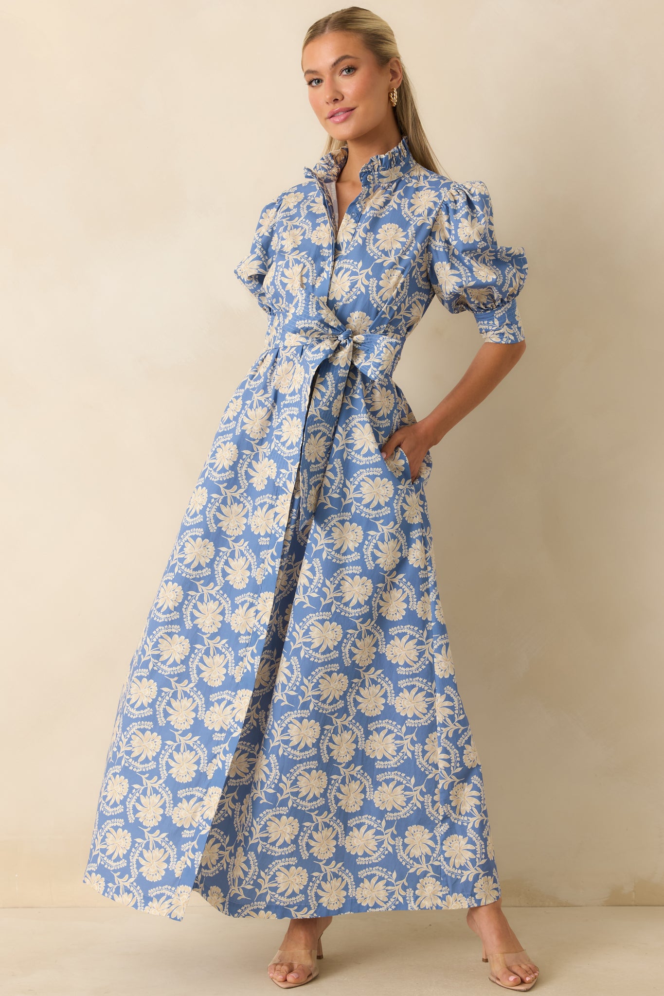 Dusty blue and ivory floral maxi dress featuring a ruffled stand collar, split neckline, puff sleeves, and a self-tie waist.