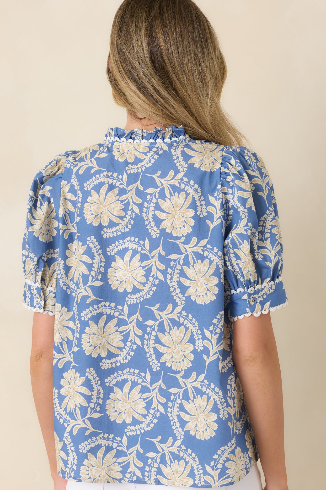 Rear view of the floral cotton blouse highlighting the relaxed silhouette, puff sleeves, and soft gathered drape.