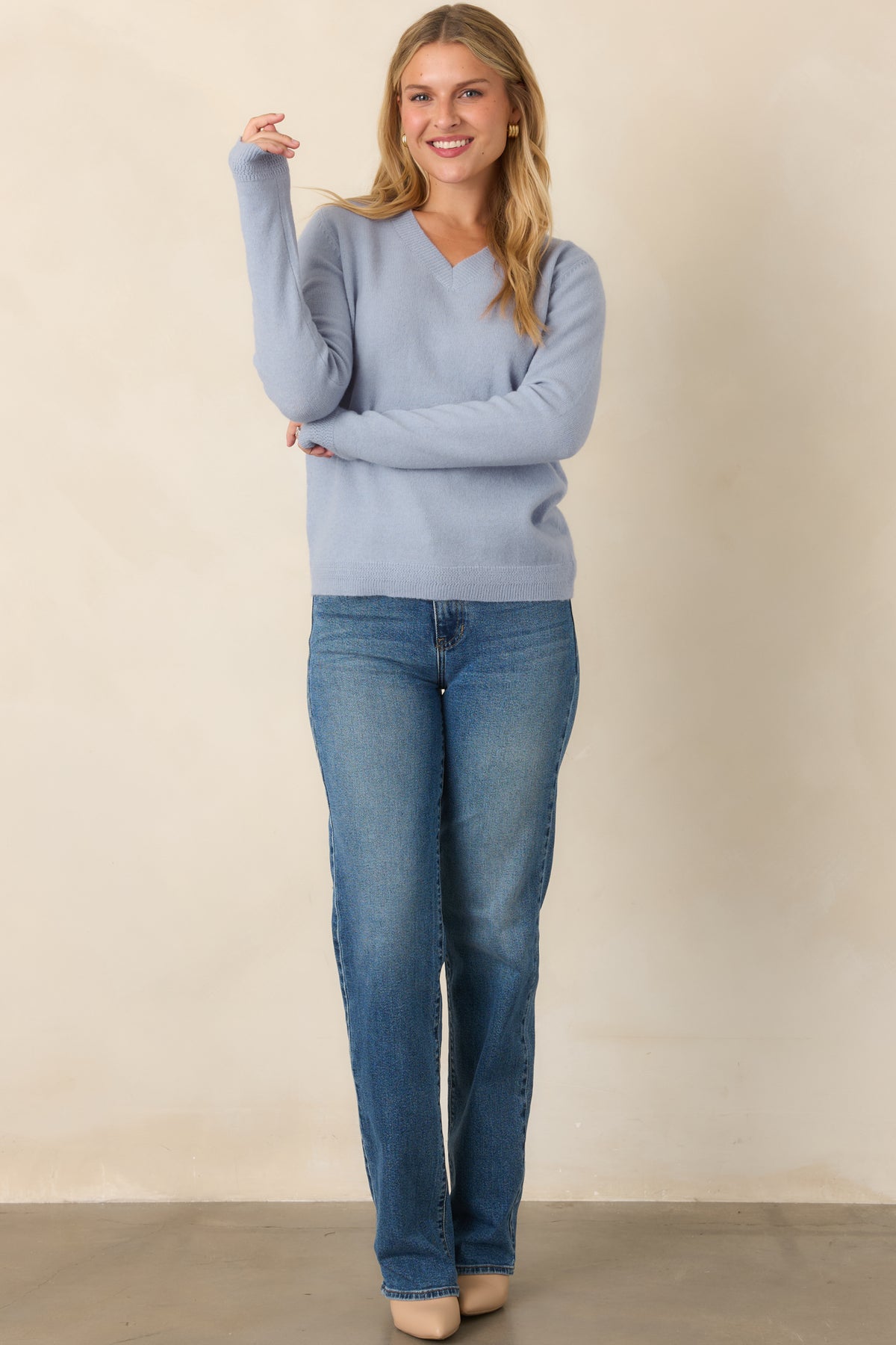 Dusty blue wool-blend knit top showcasing a softly relaxed shape, long sleeves, V-neckline, and textured ribbed hem and cuffs.