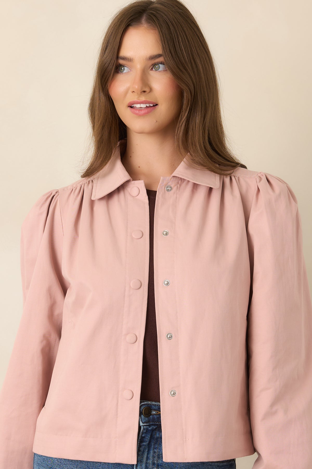 Close view of the jacket’s voluminous puff sleeve, gathered shoulder, and elasticized cuff in soft dusty pink.
