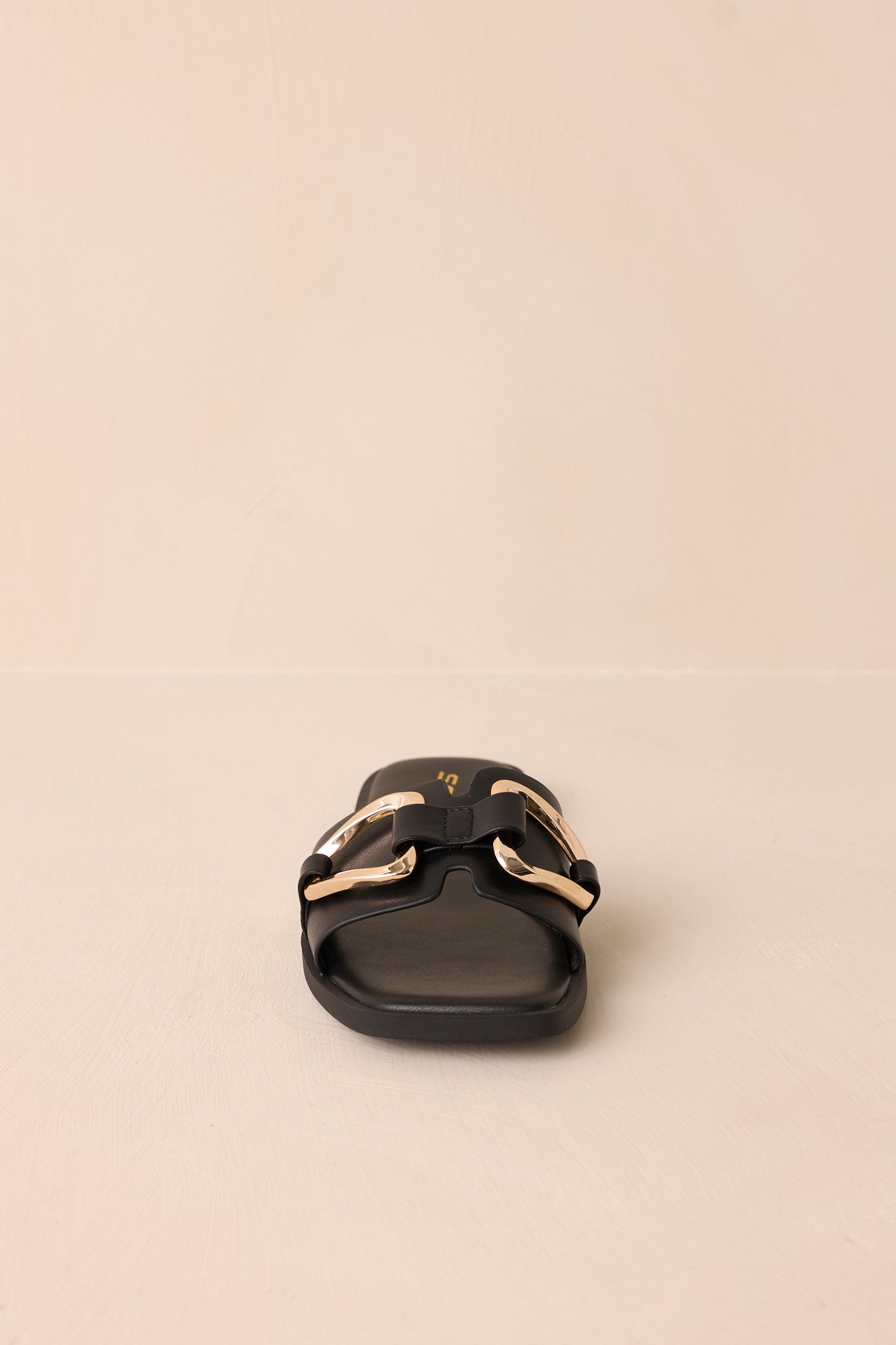 A dynamic shot showing the slip-on design, gold buckle, and notched band from a slightly angled perspective.