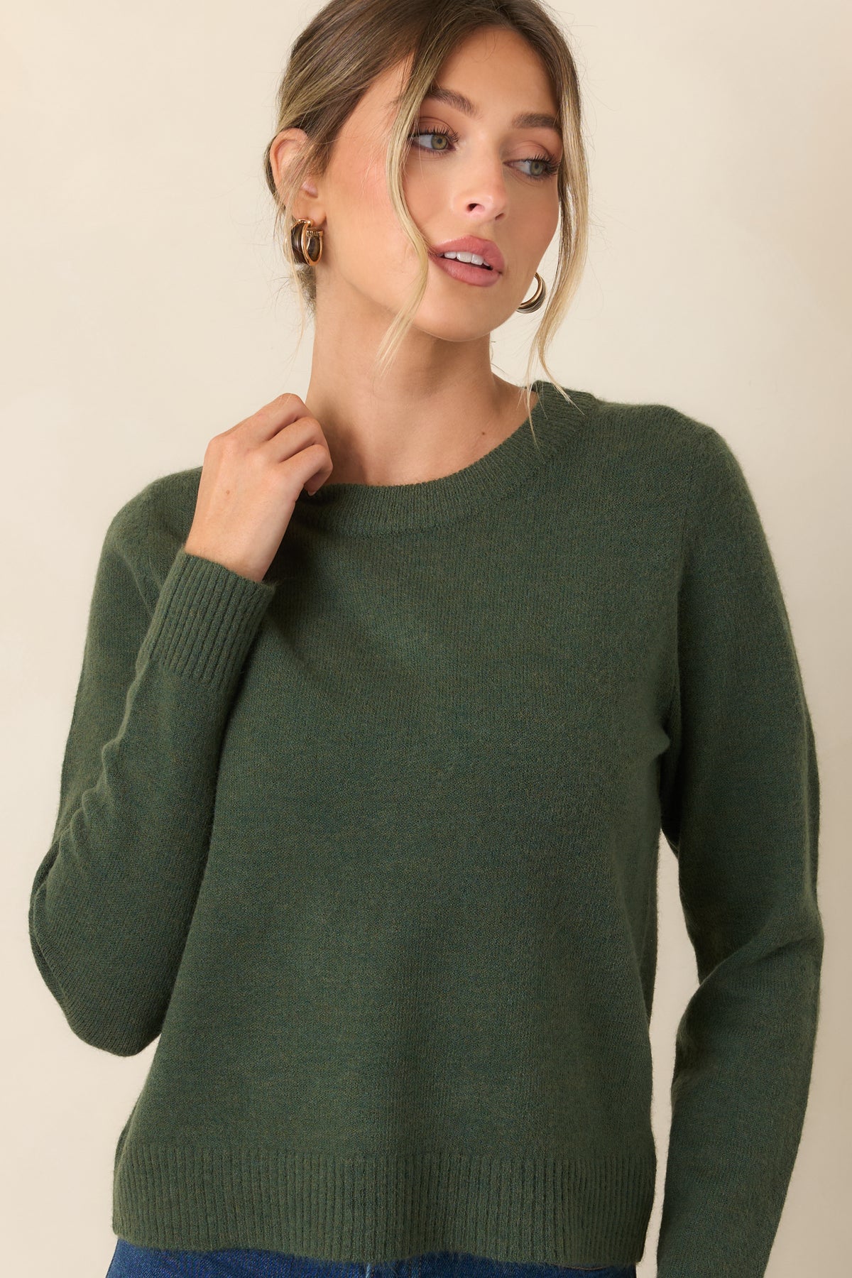 Earthy green sweater with long sleeves and gently relaxed proportions.