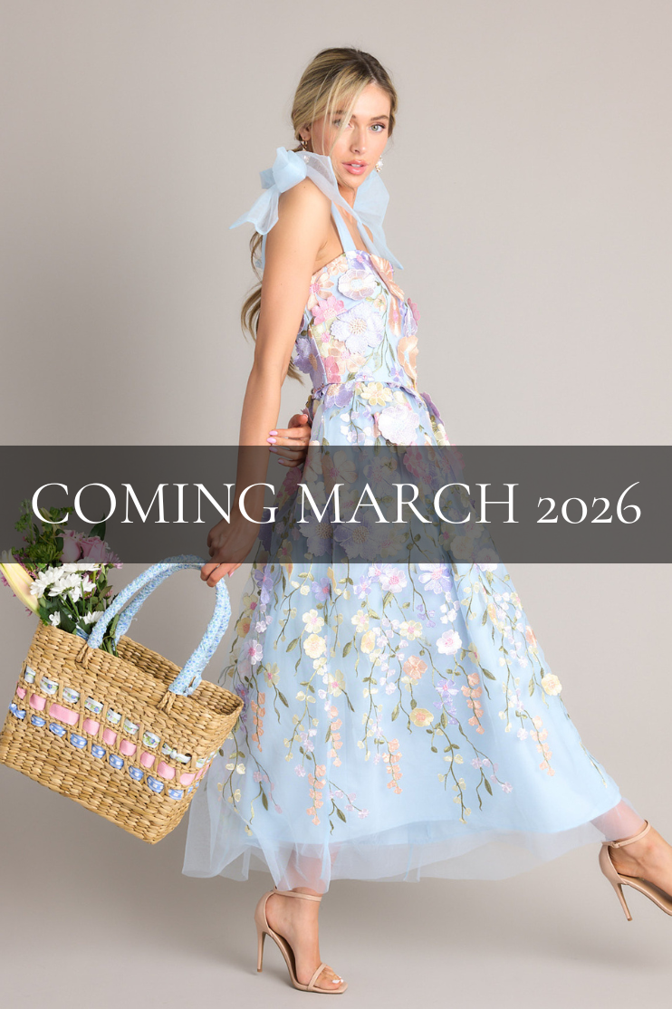 Coming March 2026. This blue multi dress features a square neckline, tulle ribbon self-tie straps, a hidden zipper at the back, and an embroidered floral design throughout the dress.