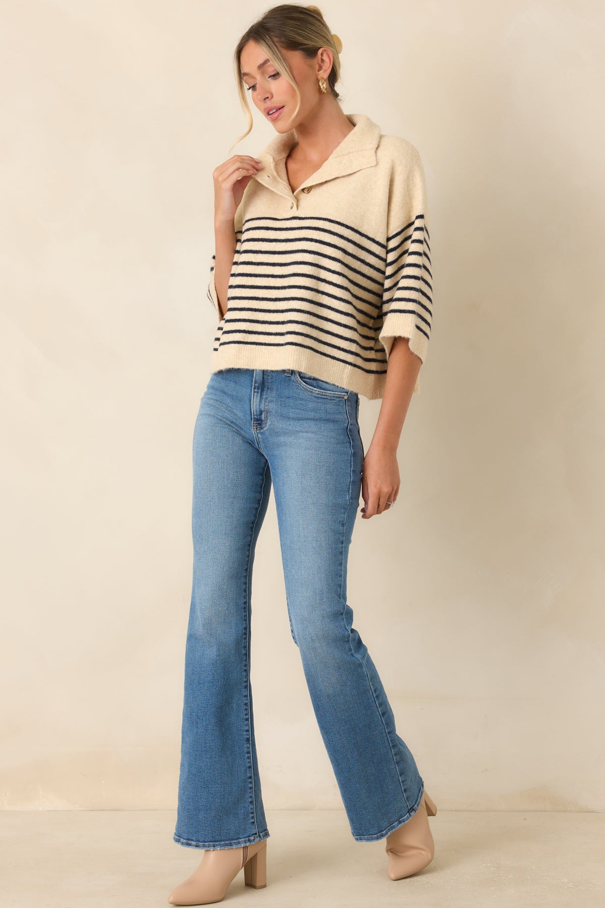 Ecru and navy top featuring a laid-back fit, brushed knit texture, and timeless stripe detailing.
