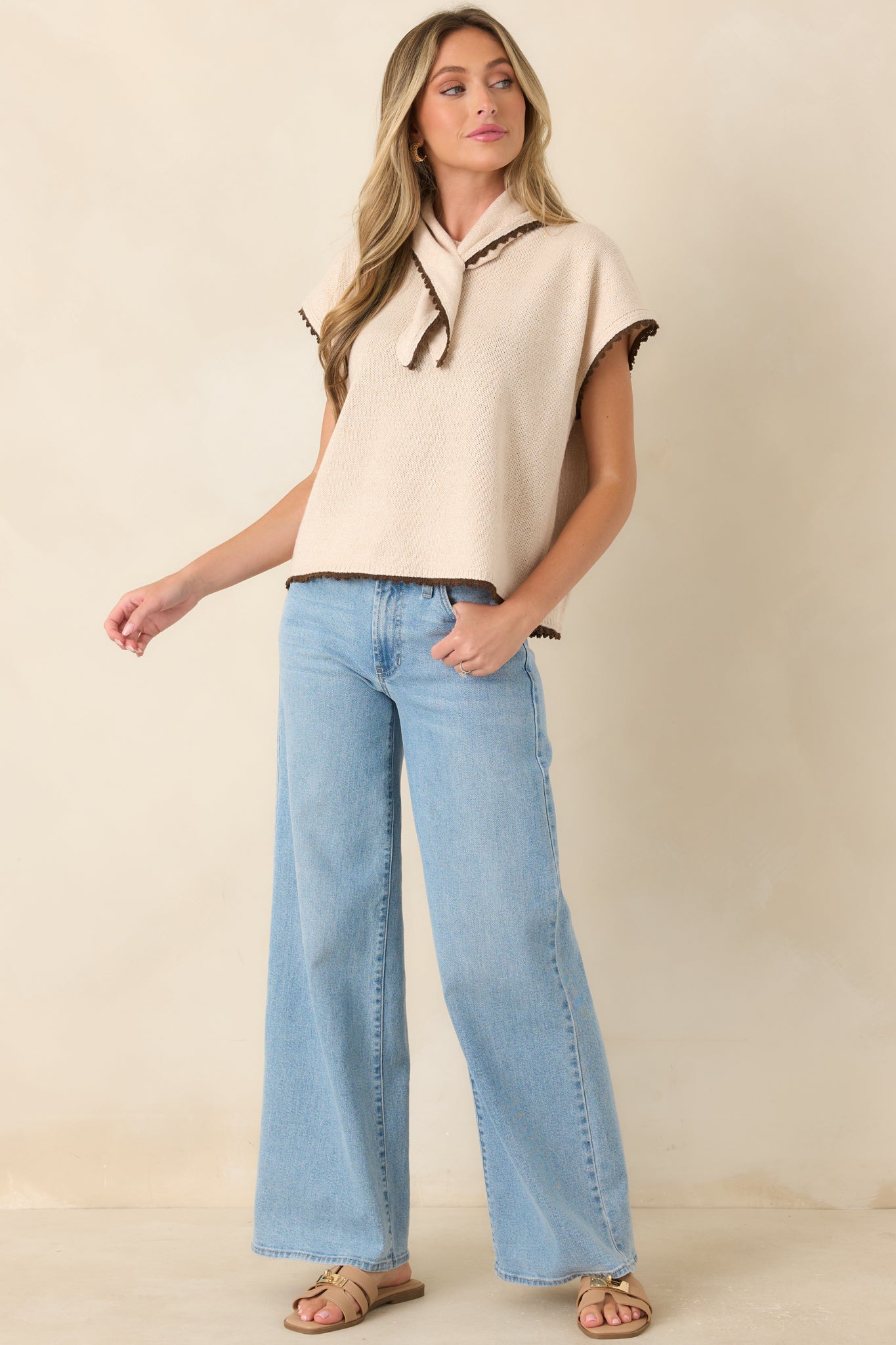 Ecru boxy knit top with a built-in scarf detail, chocolate edging, short sleeves, and a polished relaxed fit.