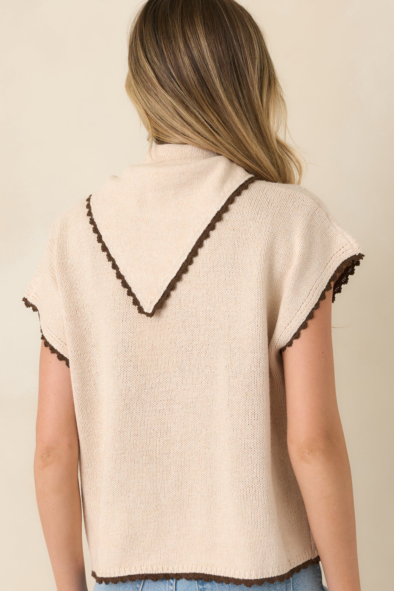 Rear view of the ecru cotton knit top featuring a relaxed boxy silhouette, short sleeves, chocolate trim, and a clean back design.
