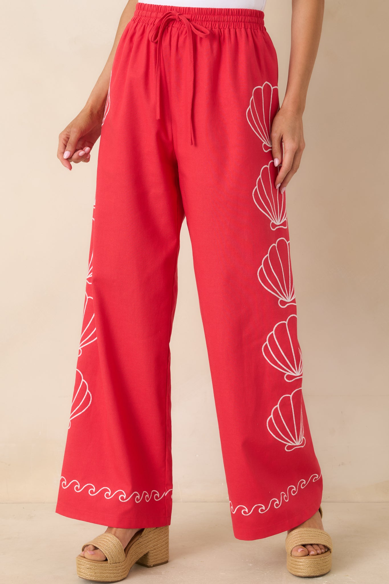 Elastic waistband with adjustable drawstring on breathable red fabric.