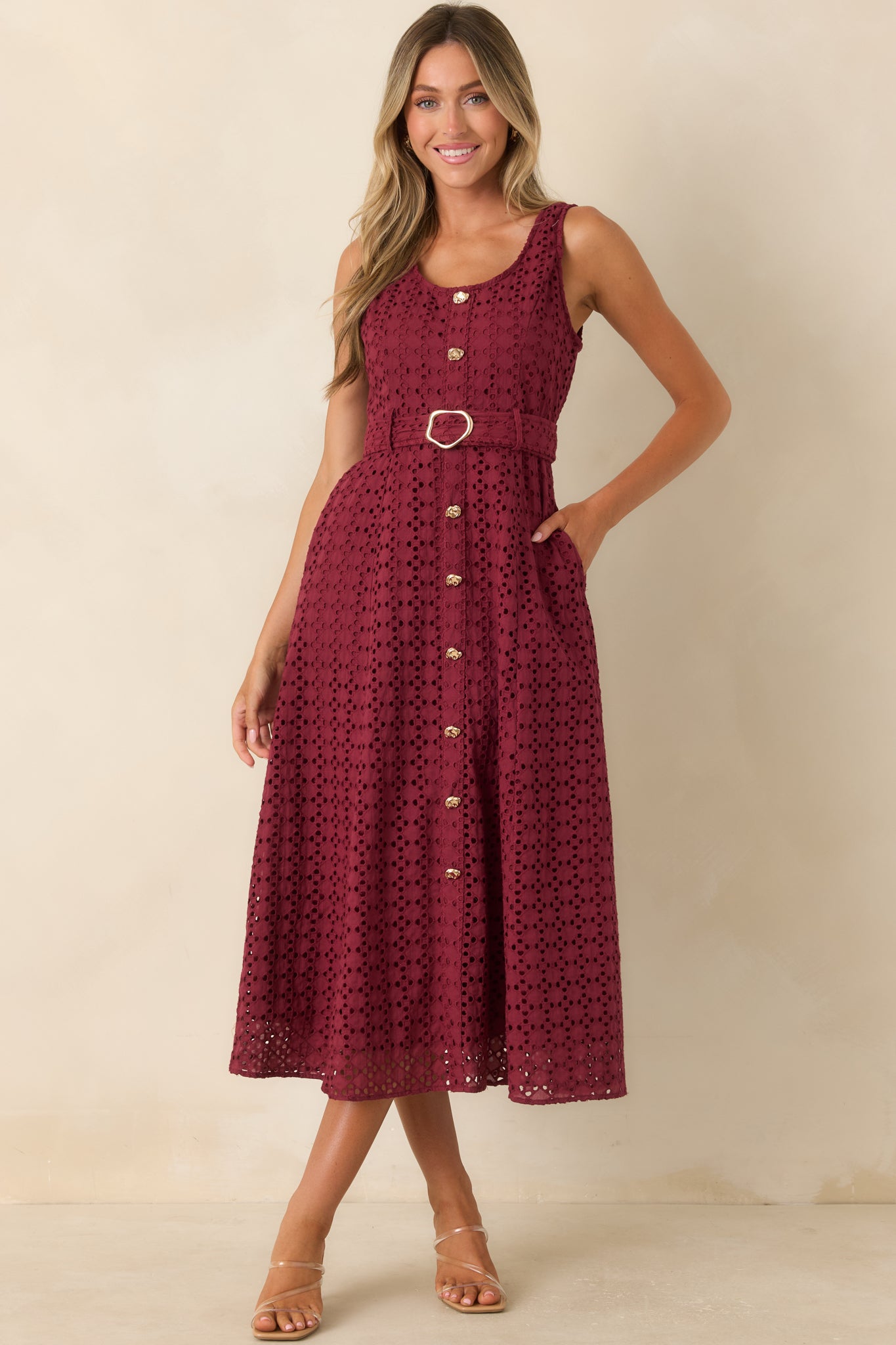Elegant cotton midi dress featuring burgundy eyelet fabric, a flattering belted waist, sleeveless design, and practical pockets.