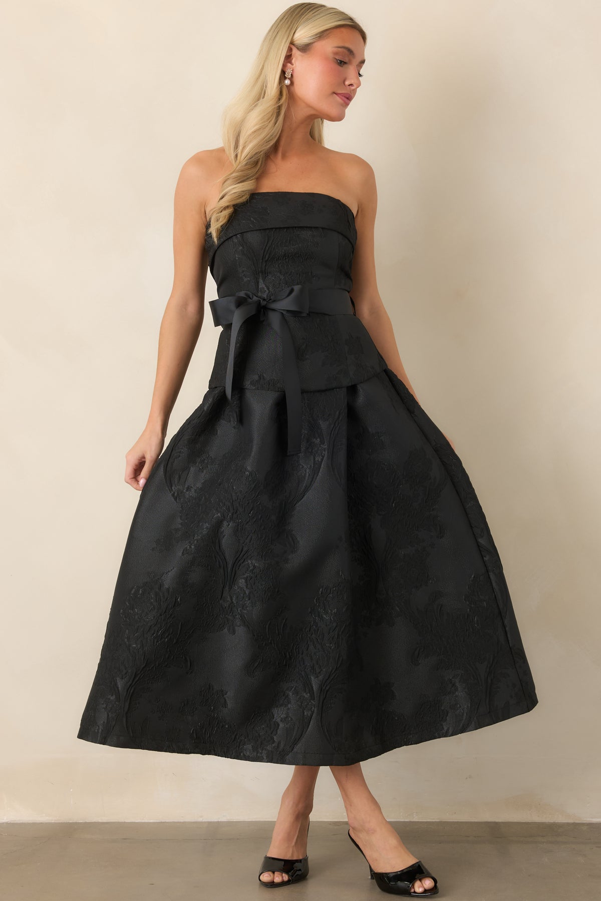 Elegant midi dress with a folded strapless neckline, defined waist sash, and full A-line pleated skirt.