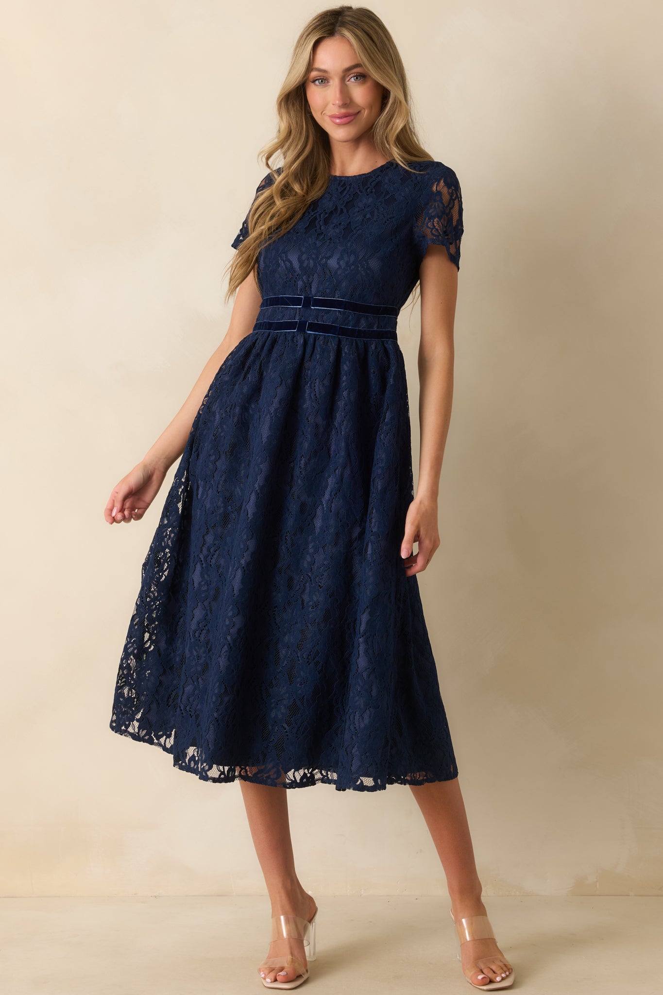 Elegant navy lace midi dress featuring short sleeves, full lining, and a structured silhouette.