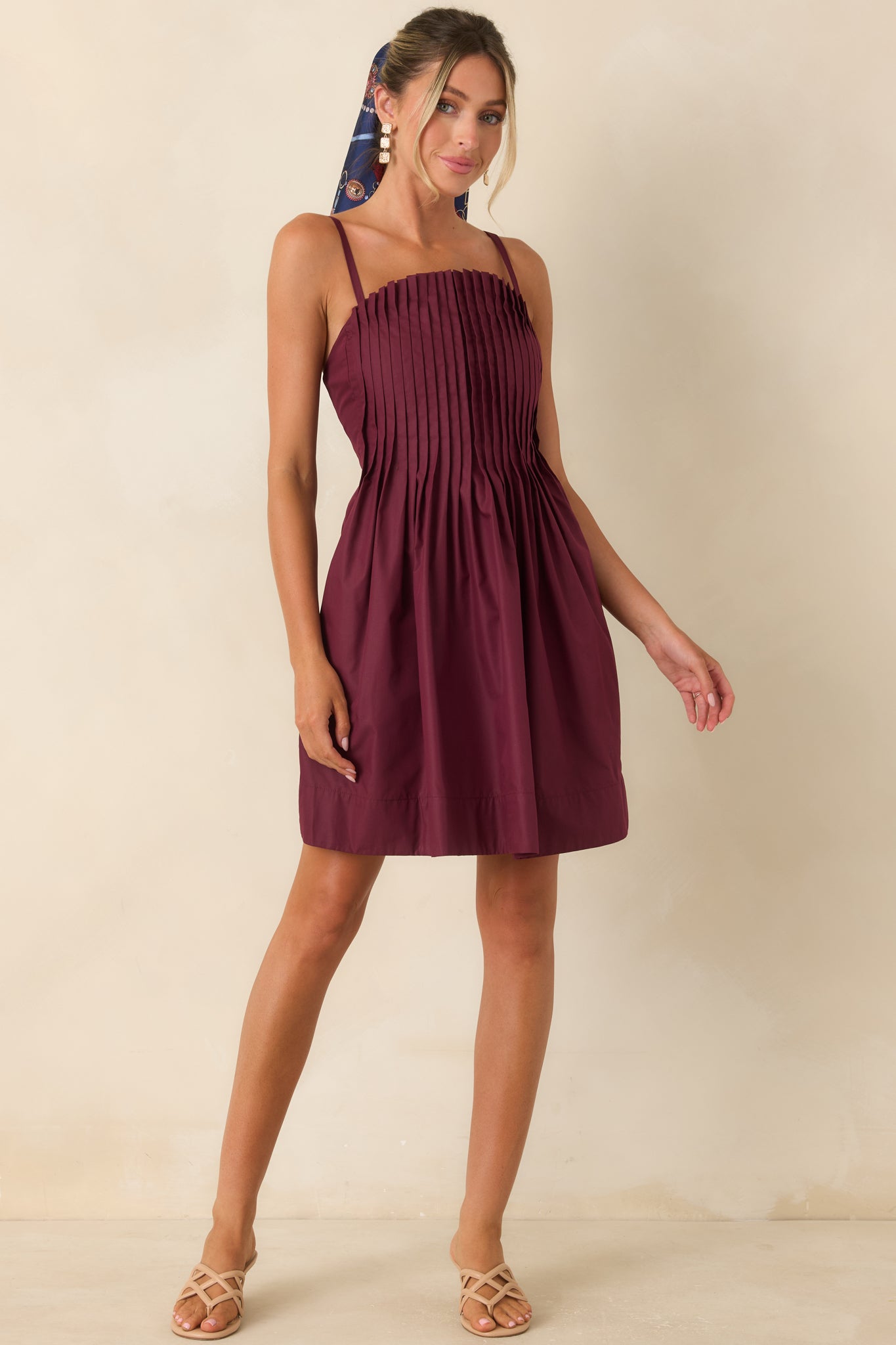 Elegant mini dress featuring structured pleats, a stretchy smocked back, and functional side pockets.