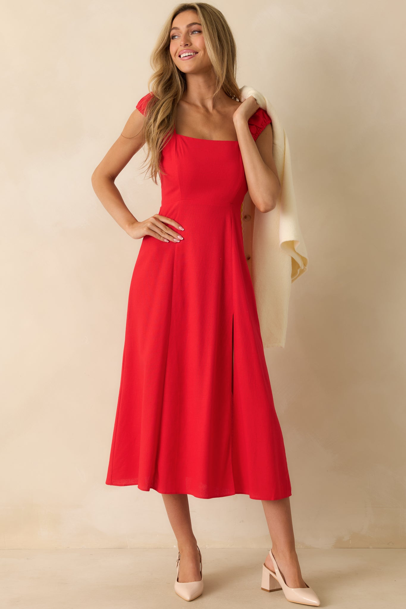 Elegant red dress featuring a square neckline, smocked back, slit up the leg, and a relaxed, flowing skirt.