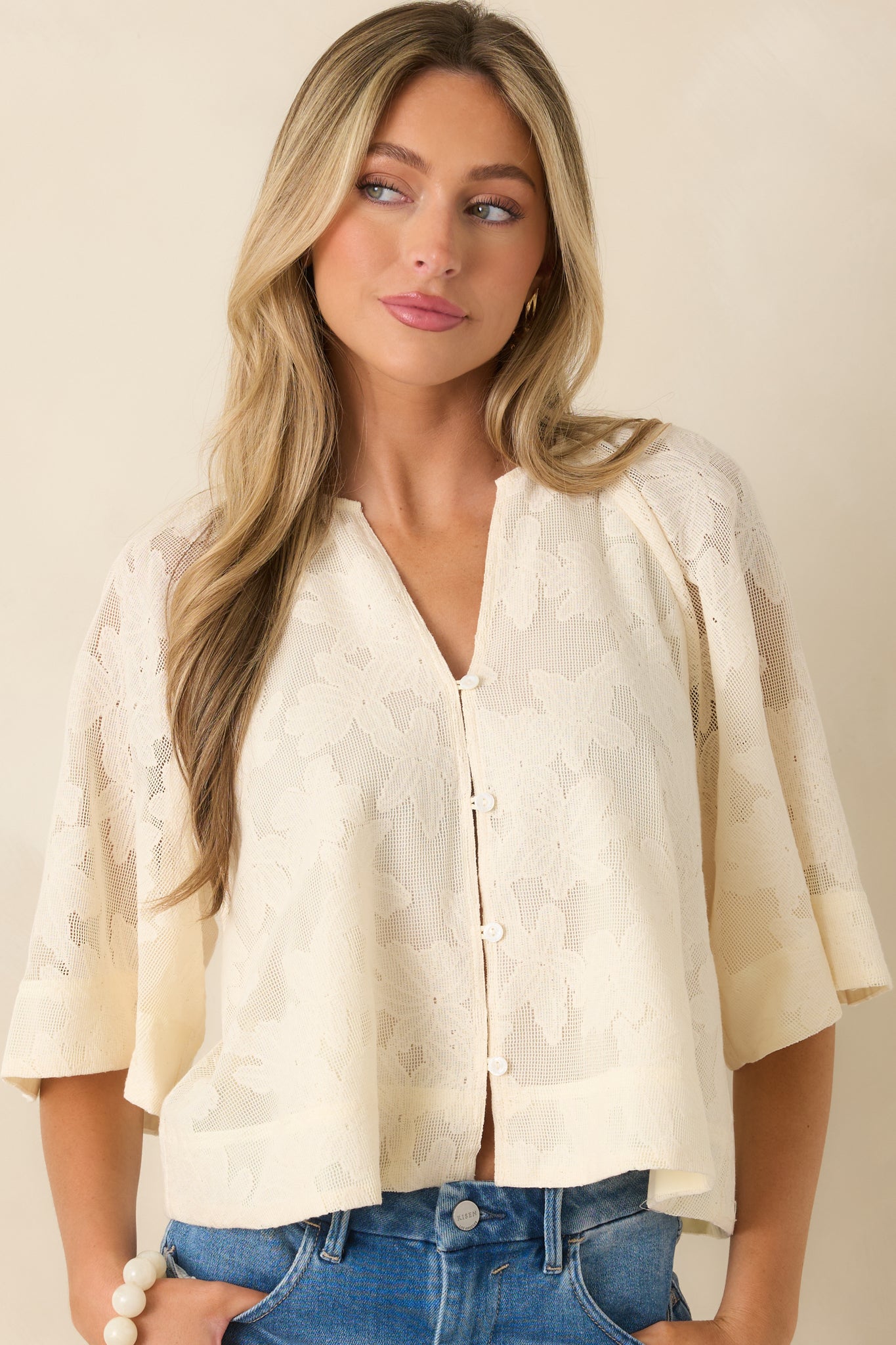 Embroidered ivory blouse featuring delicate cutwork details and textured finish.