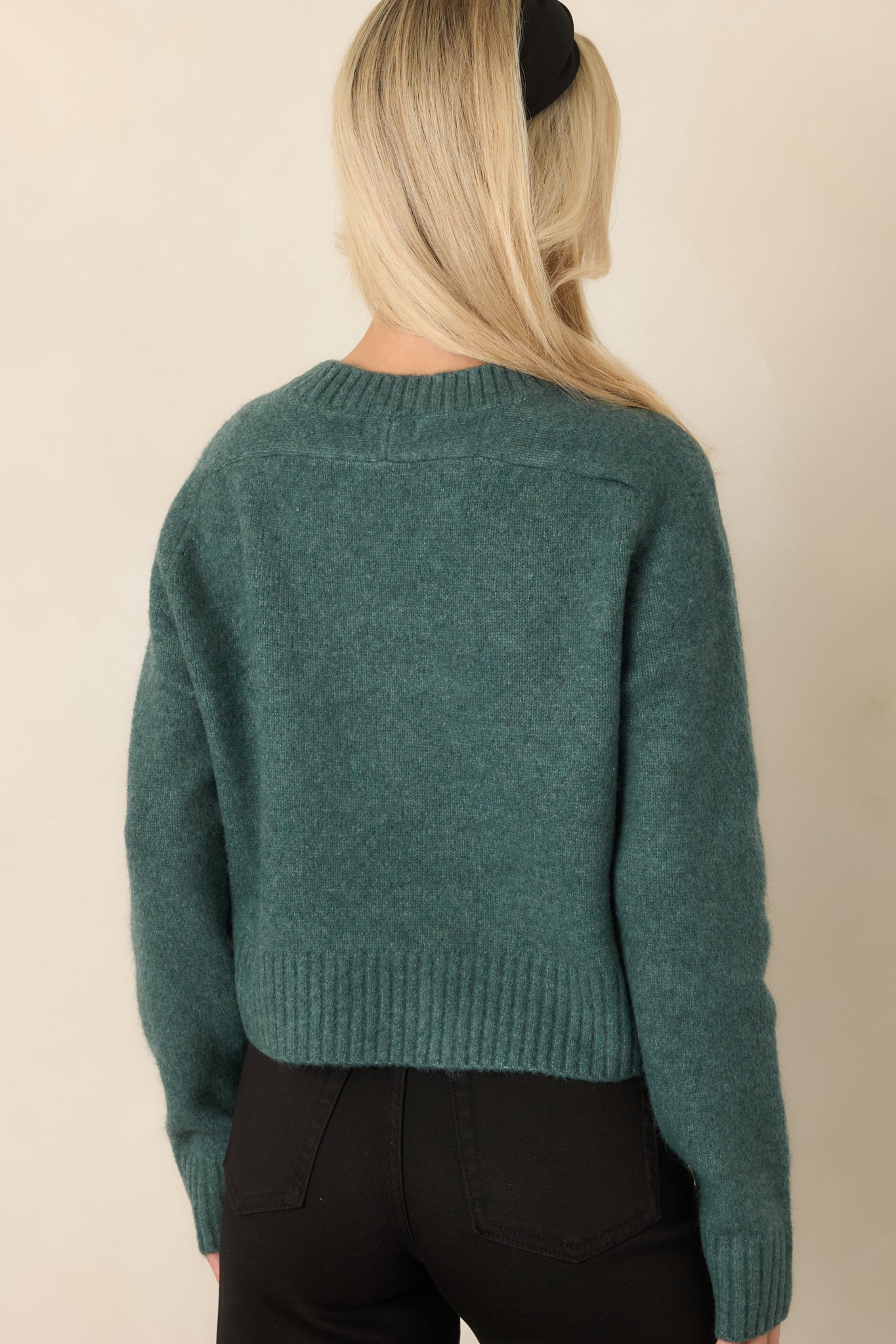 Rear view of the Emerald Cove green fuzzy knit top showing its relaxed fit, long sleeves, ribbed hem, and slightly cropped length.