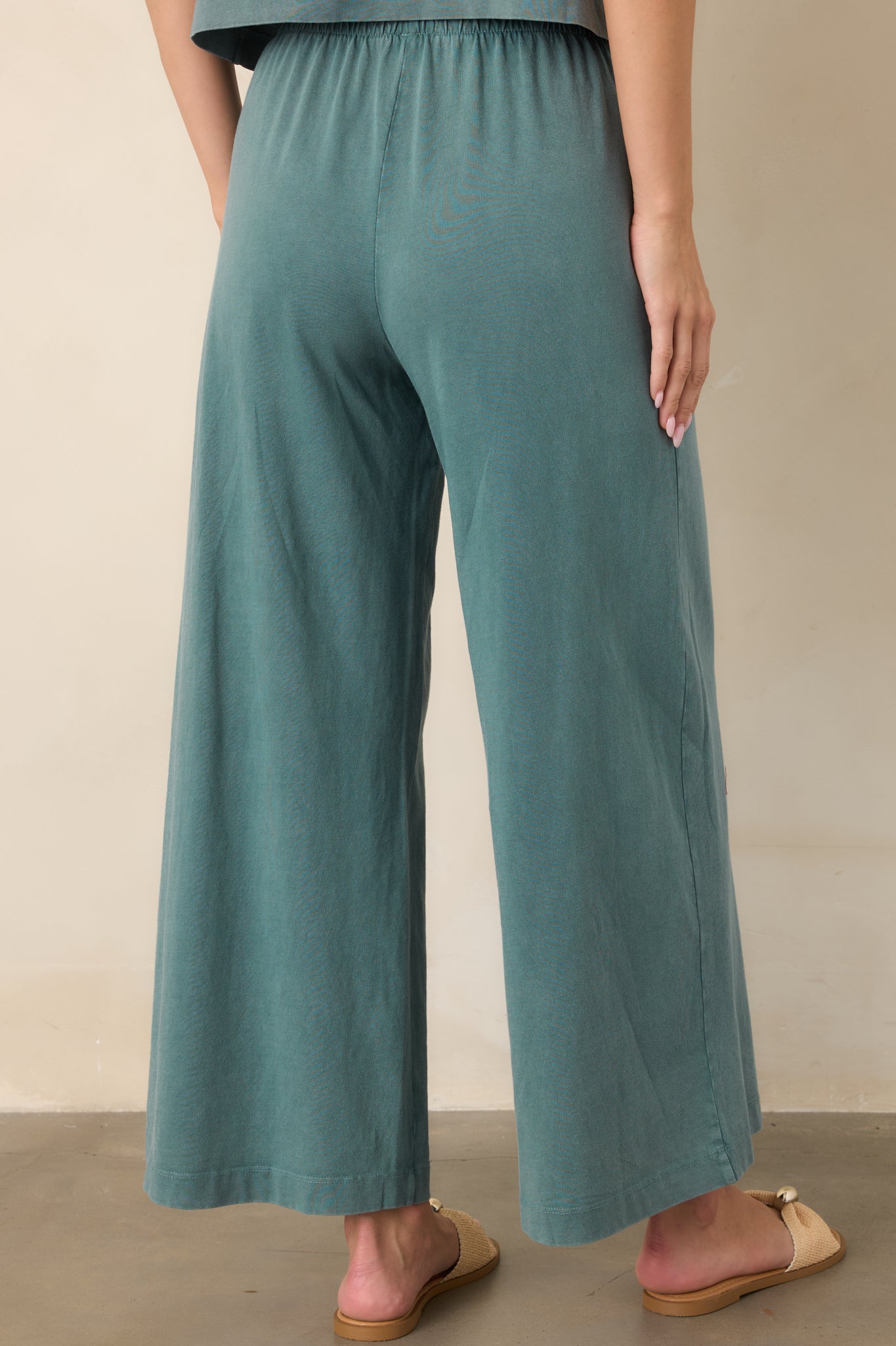 Rear view of the Emerald Cove cotton jersey pants showing the elastic waistband, relaxed wide-leg silhouette, and ankle-grazing hem.